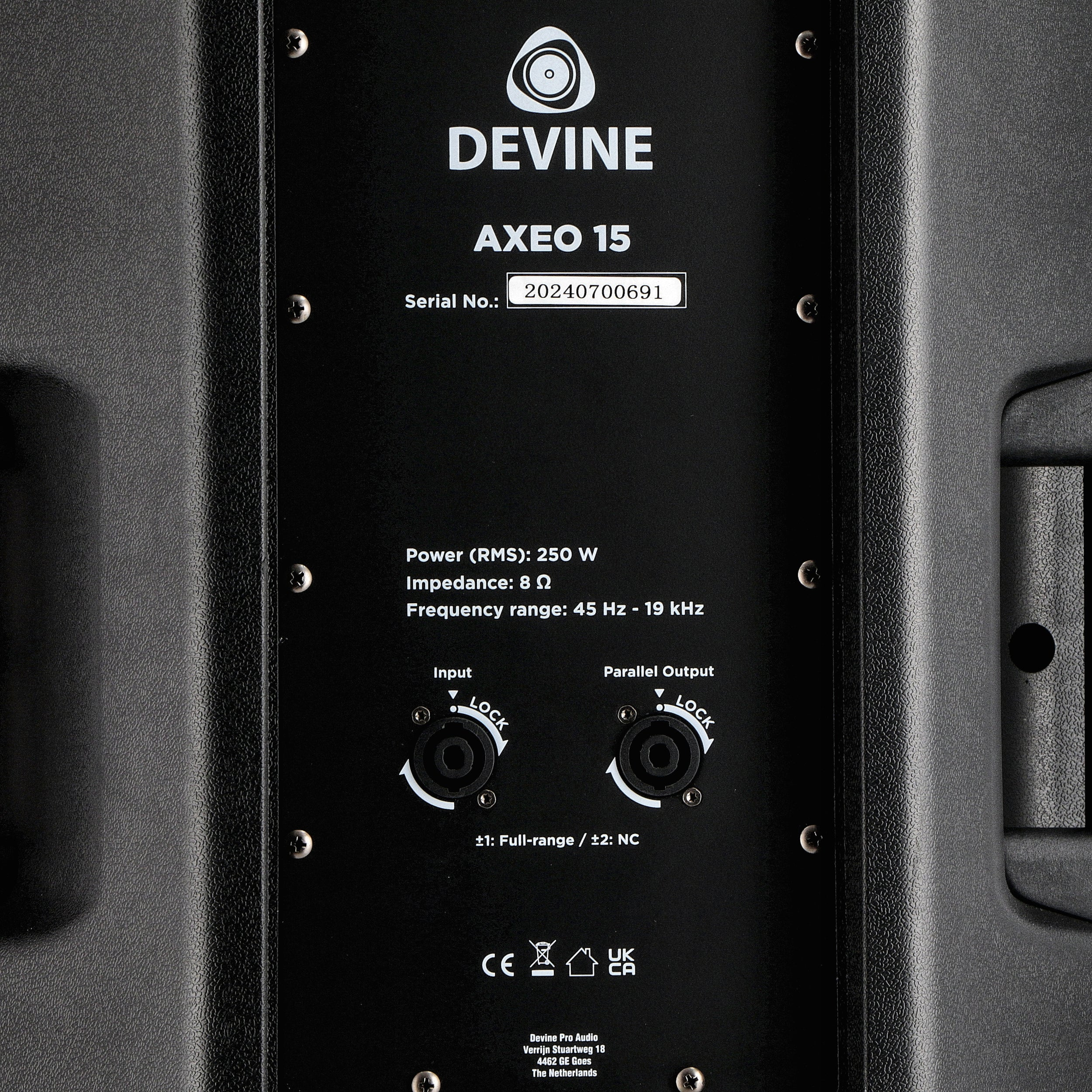 Back of a black speaker with labels: DEVINE AXEO 15, Serial No., Power, Impedance, Frequency range, connectors.