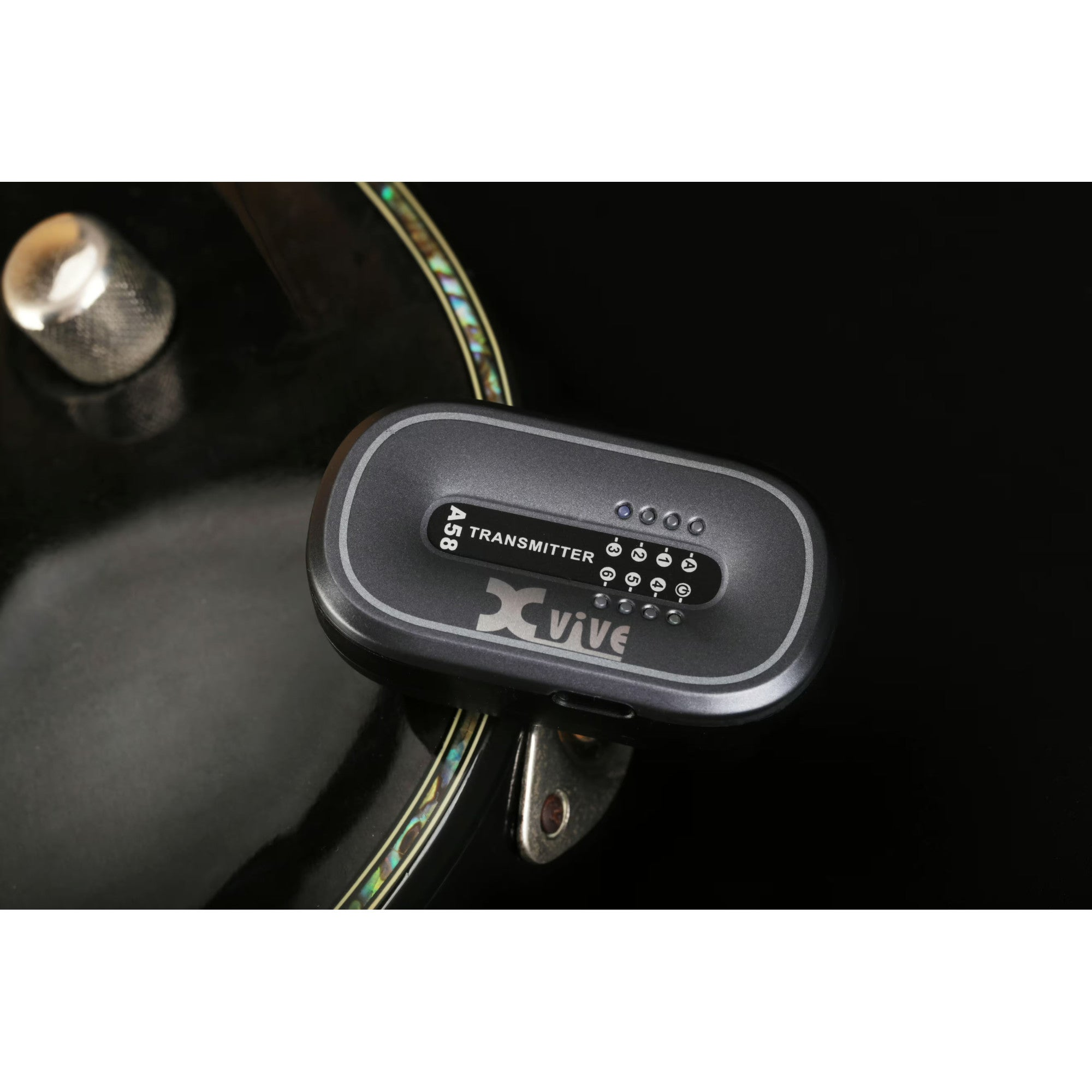 A black X VIVE A58 transmitter on a guitar, with indicators and buttons.