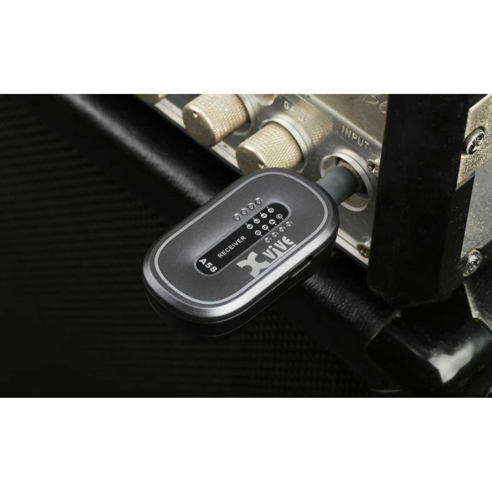 A black Xvive A58 wireless receiver is plugged into a silver input jack.