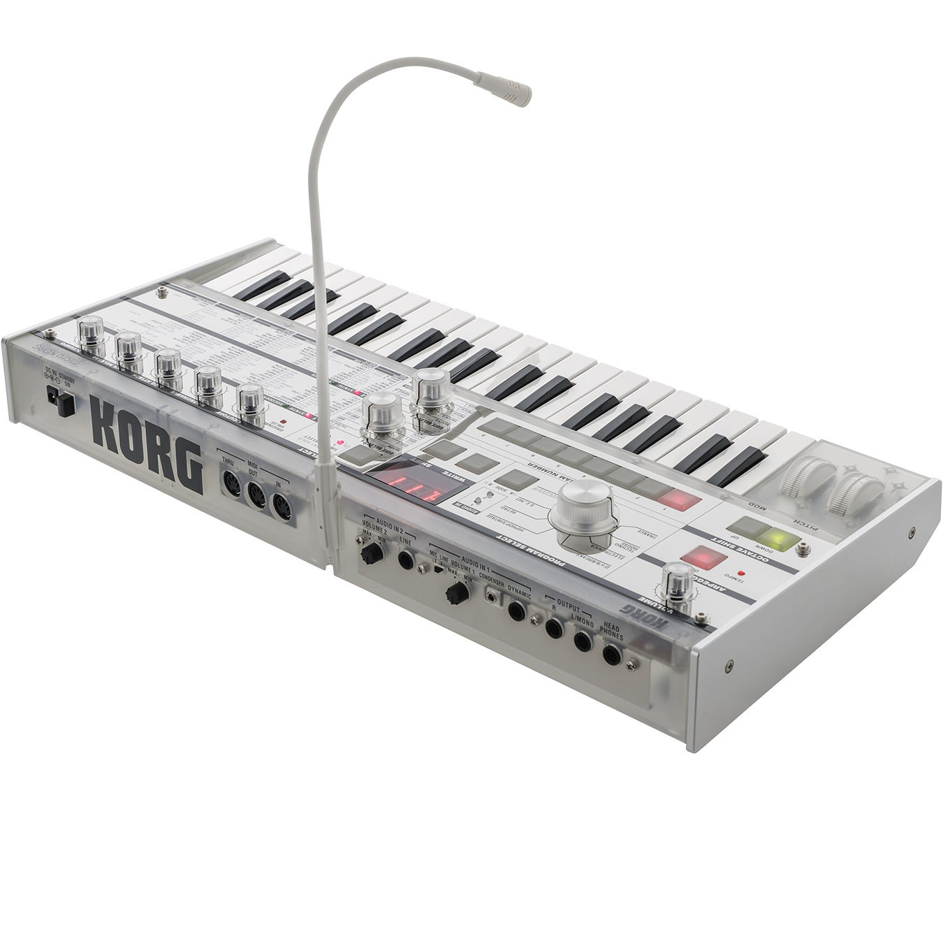 Een witte Korg synthesizer met zwarte en witte toetsen en een microfoon met zwanenhals.