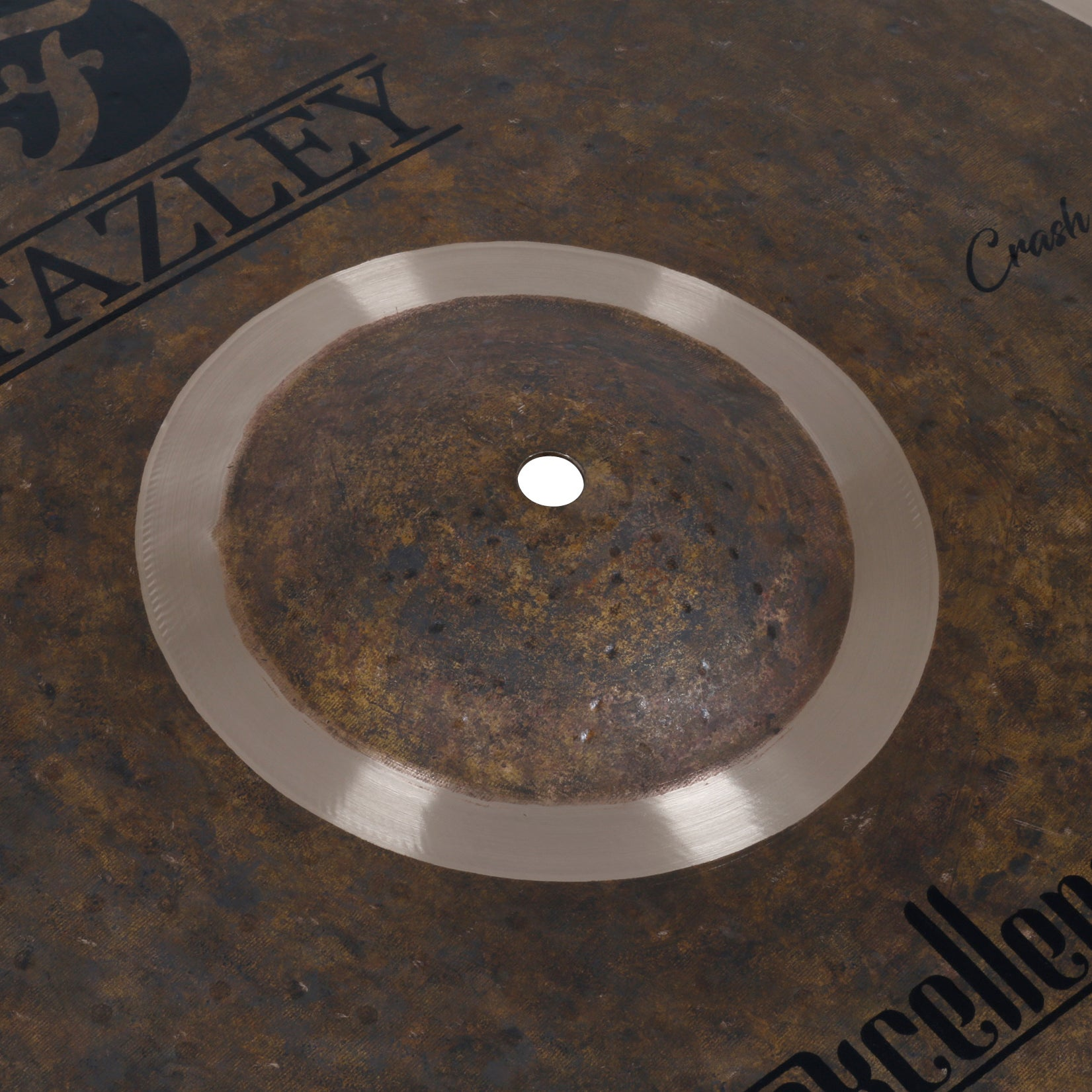 Dark cymbal with text, has a matte sheen and a hole in the center.