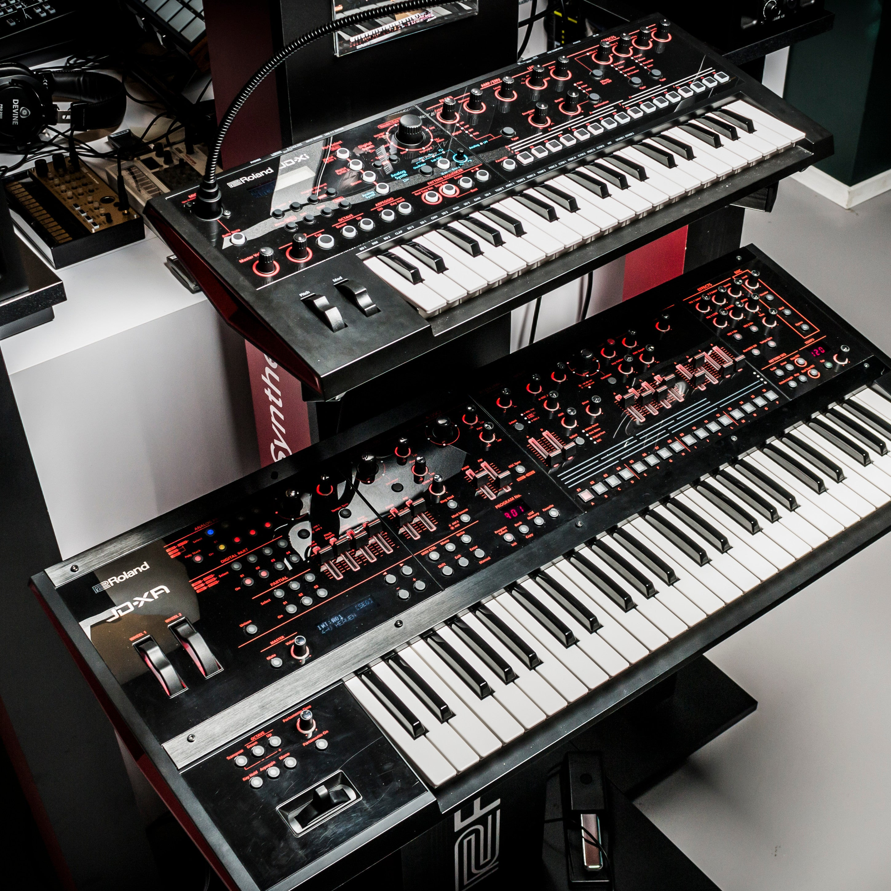 Twee zwarte Roland synthesizers met witte toetsen en rode bedieningselementen.