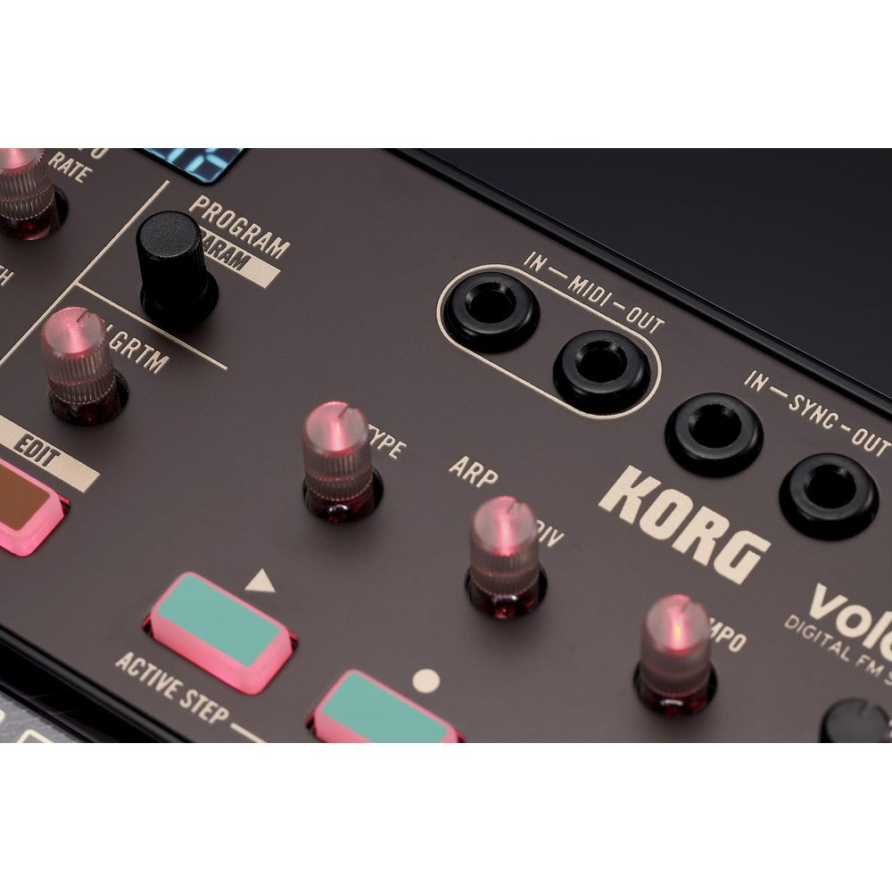 Close-up van een Korg synthesizer met knoppen, schakelaars en poorten.