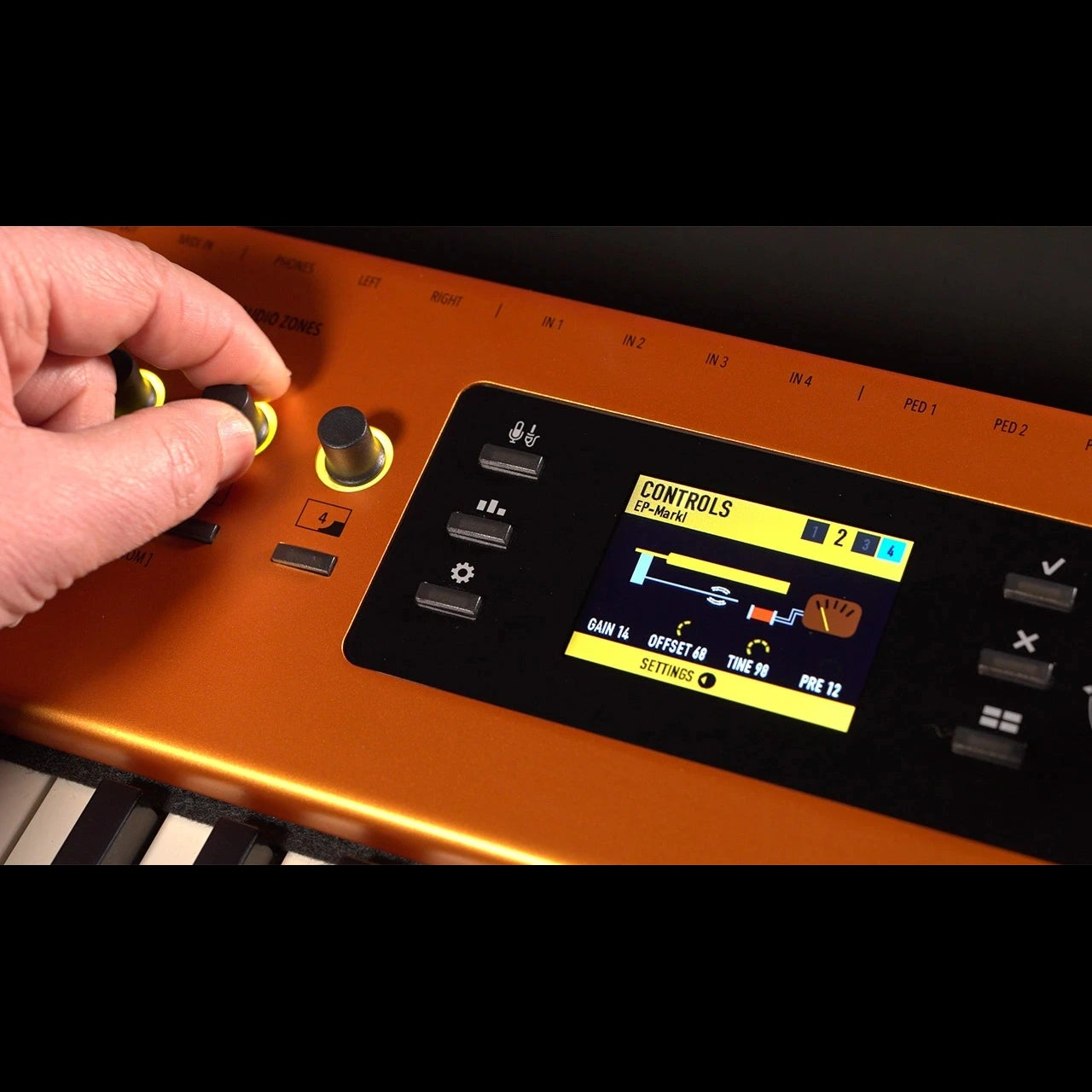 Een hand draait aan een knop op een oranje keyboard met digitaal scherm met instellingen.