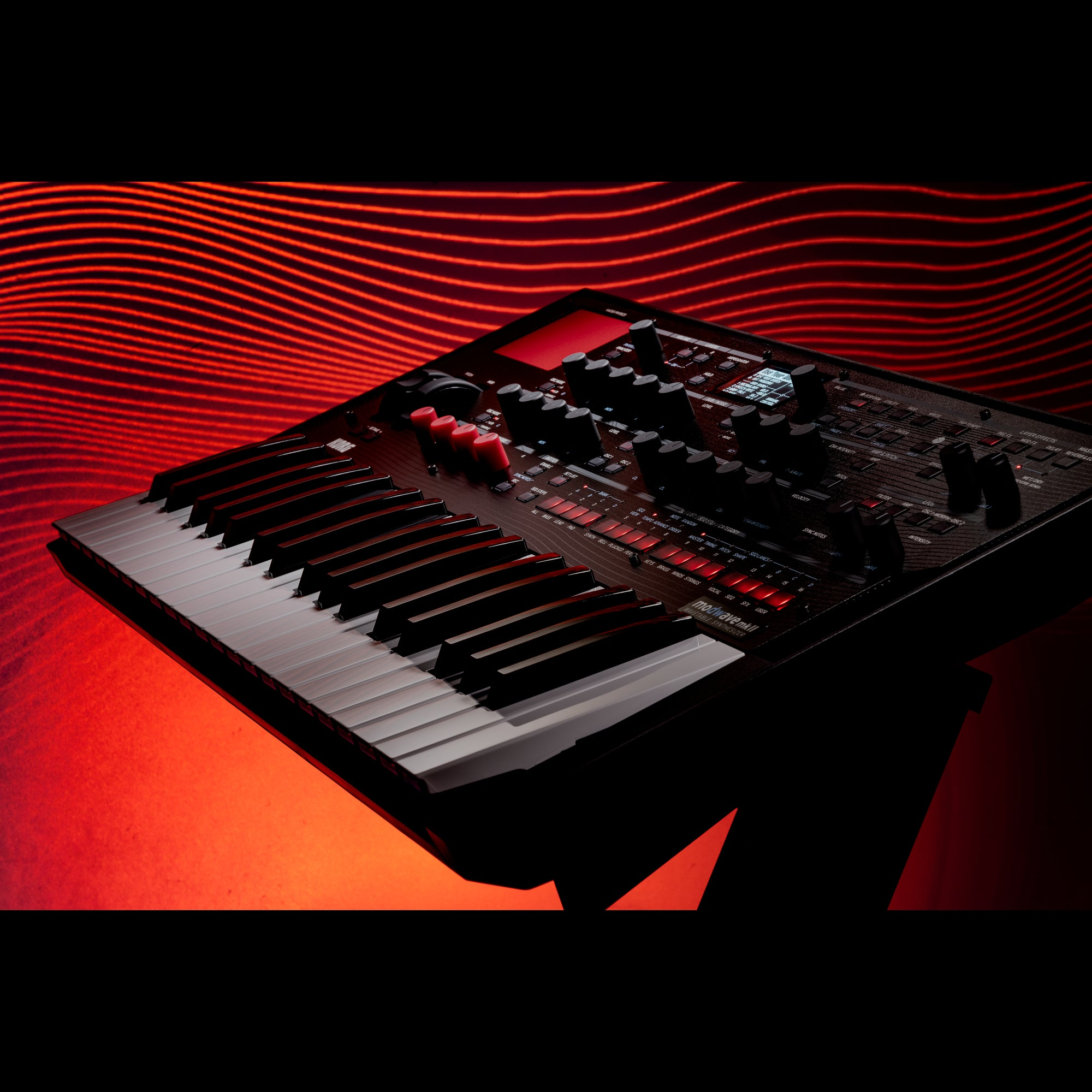 Een zwarte synthesizer met toetsenbord tegen een rode, golvende achtergrond.