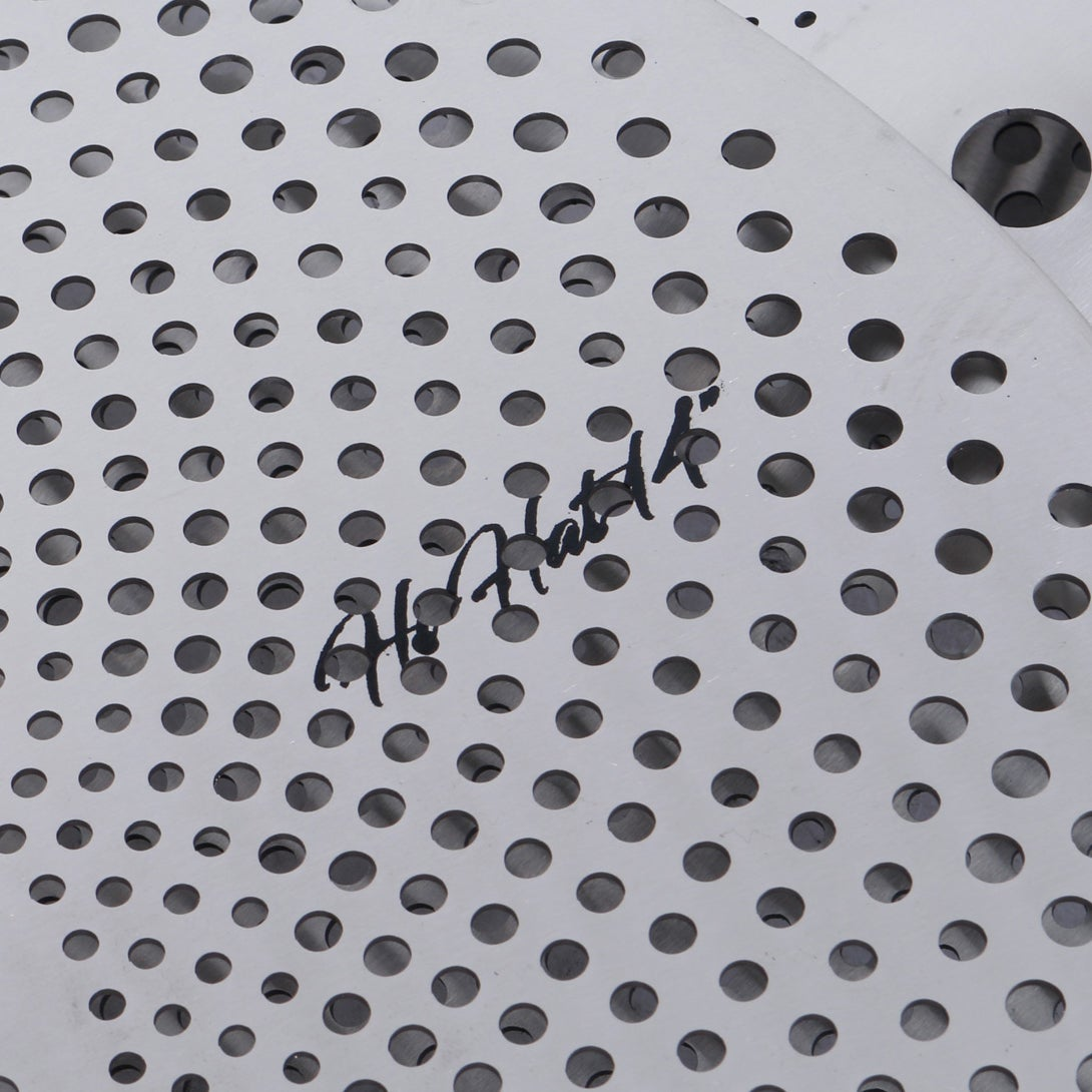 Silver perforated metal with black handwriting.
