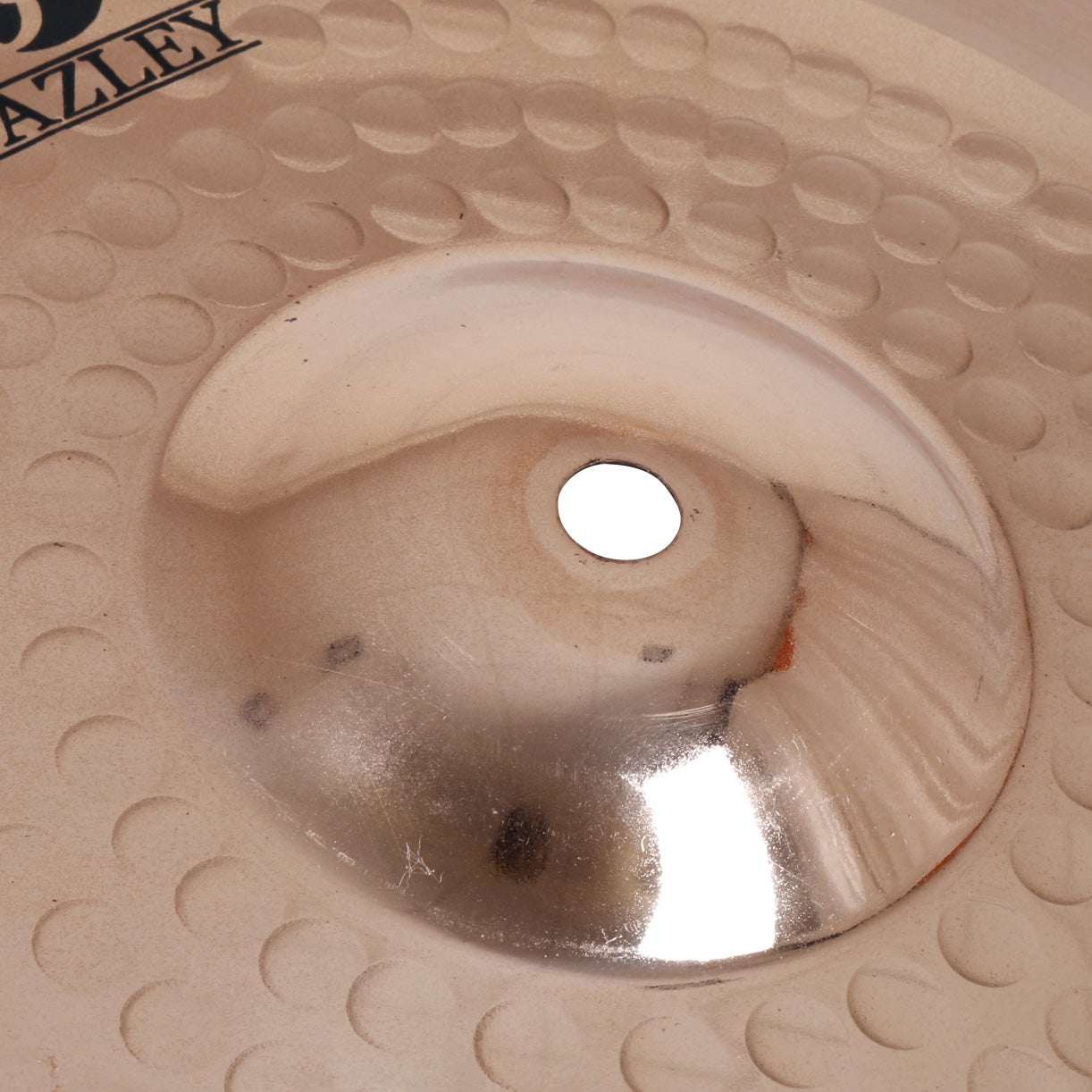 A close-up view of a bronze cymbal with the brand name 'AZLEY' visible in black lettering.
