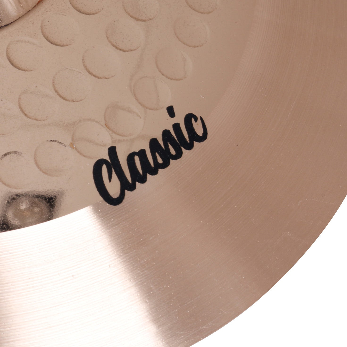 Part of a gold cymbal with the word "Classic" in black script.