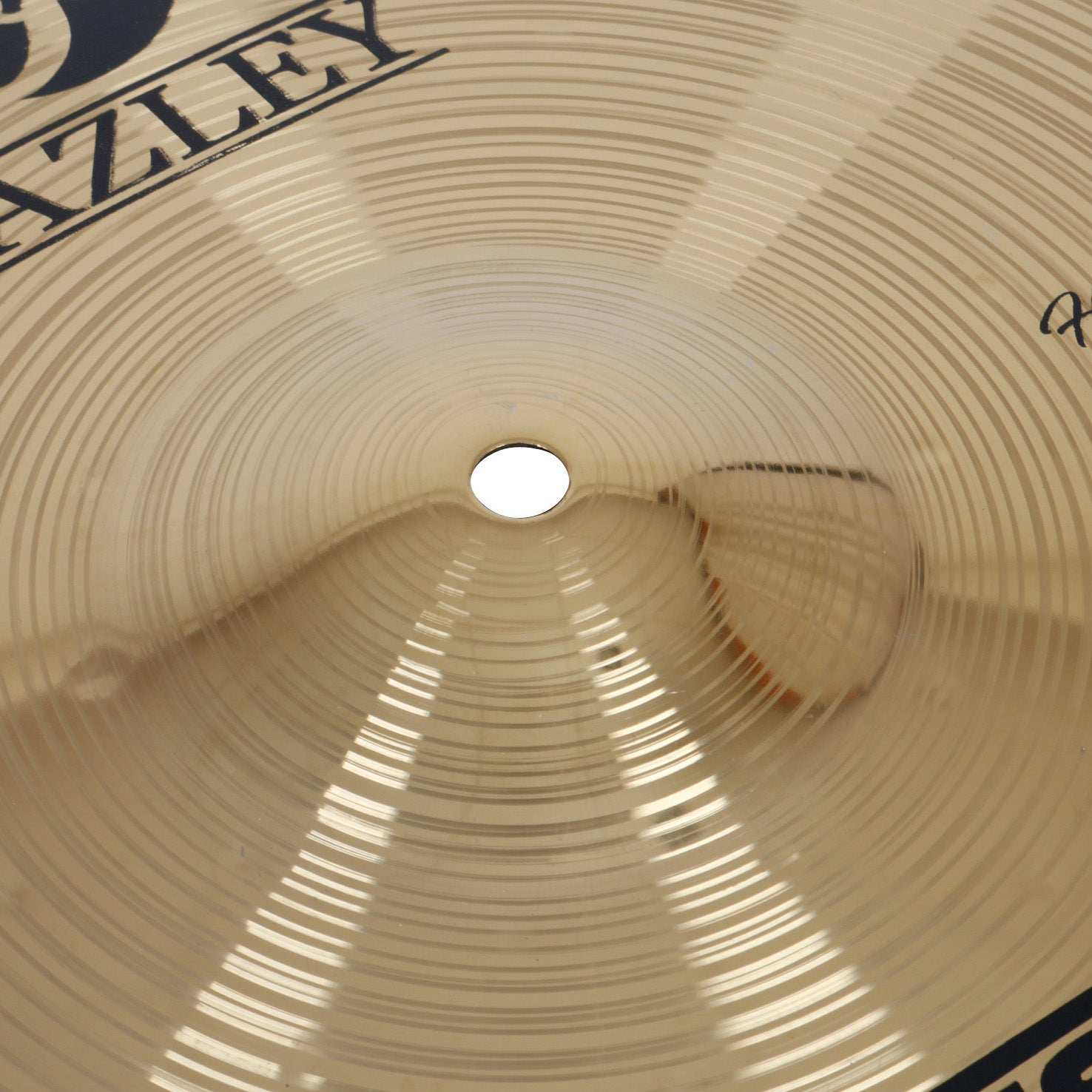 A golden cymbal with concentric grooves and a hole in the center.