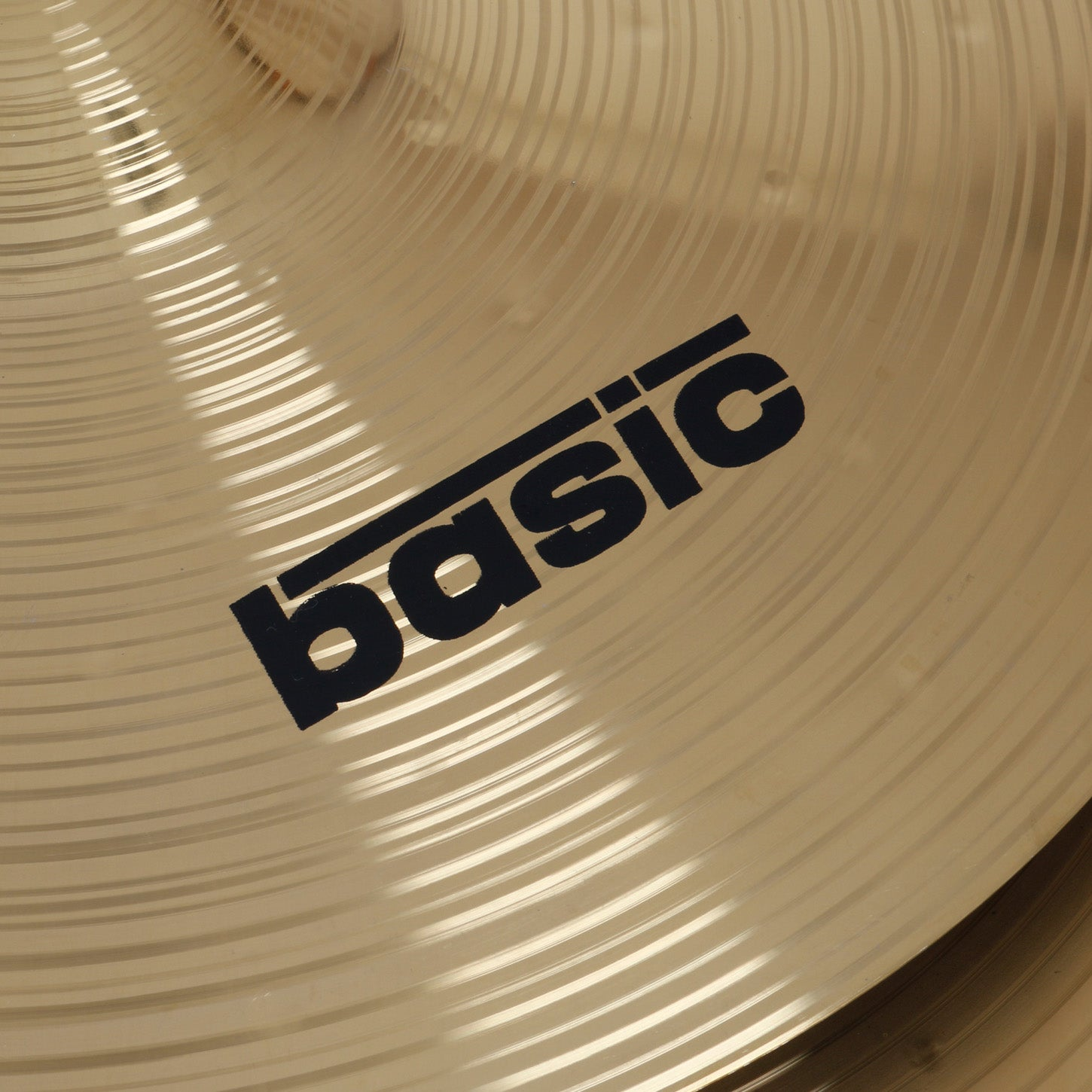 A golden cymbal with a black 'basic' logo and concentric grooves.