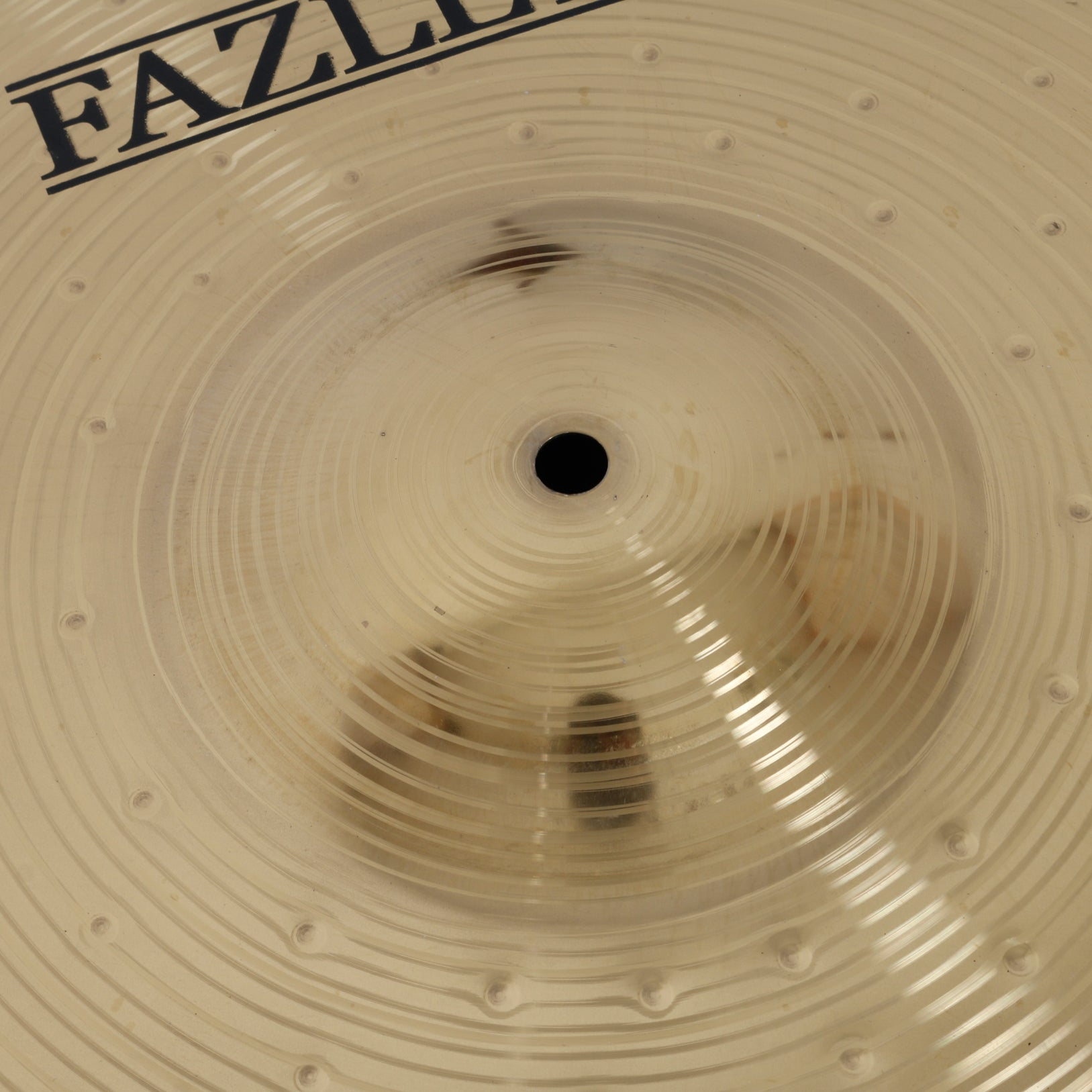 Golden cymbal with concentric grooves and the "FAZL" logo.