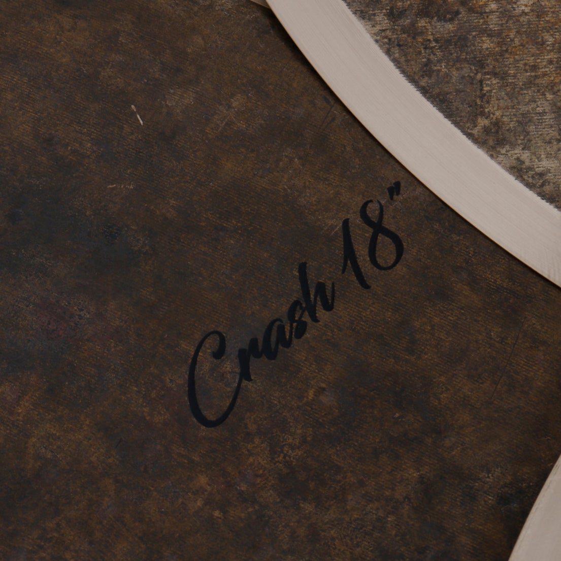Dark brown surface with 'Crash 18' written in black script.