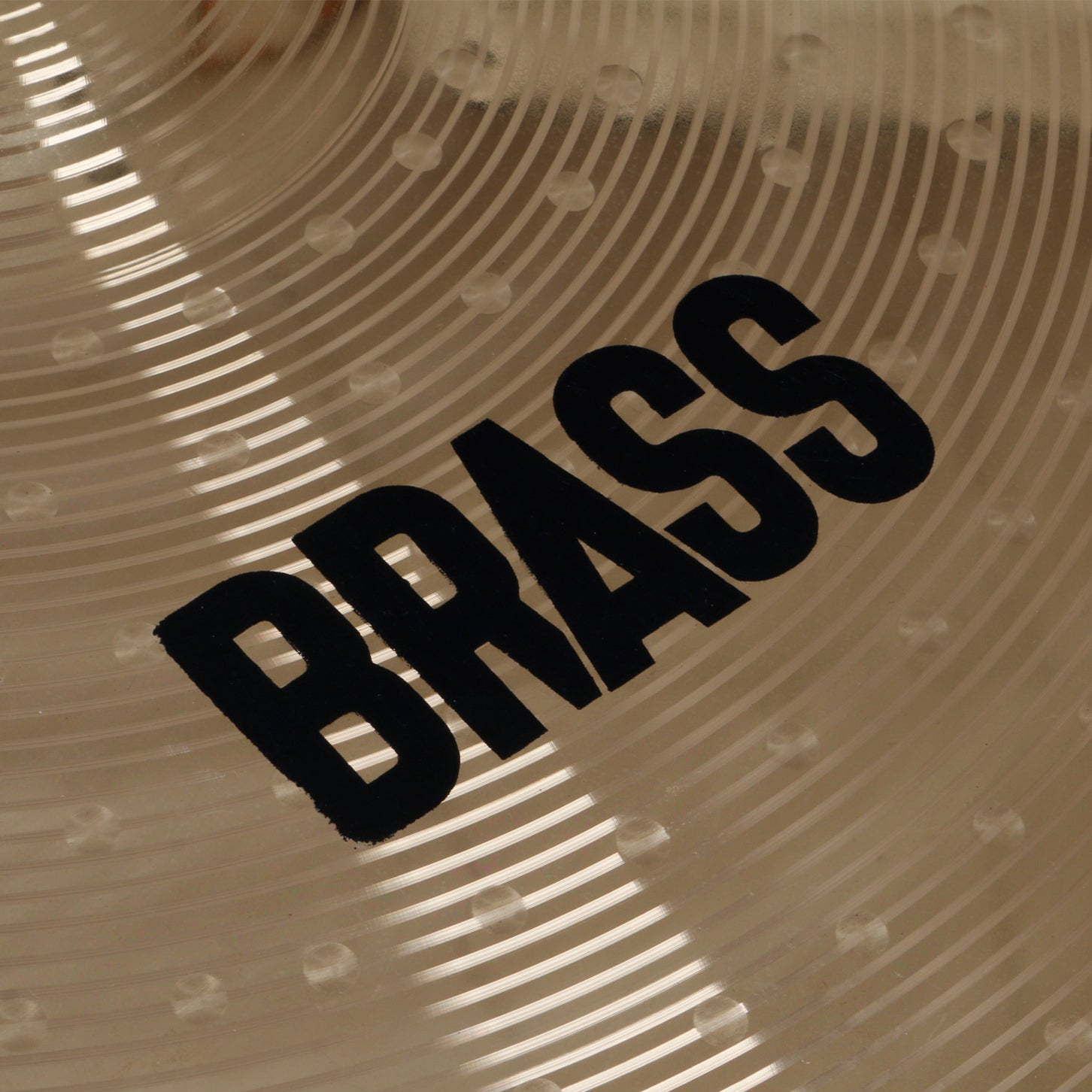 Close-up of a cymbal with the word "BRASS" in black lettering.