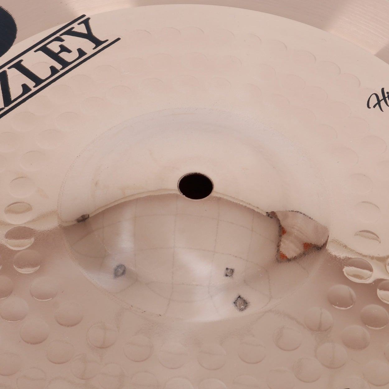 A light-colored cymbal with a hole in the center and the logo 'ZLEY'.
