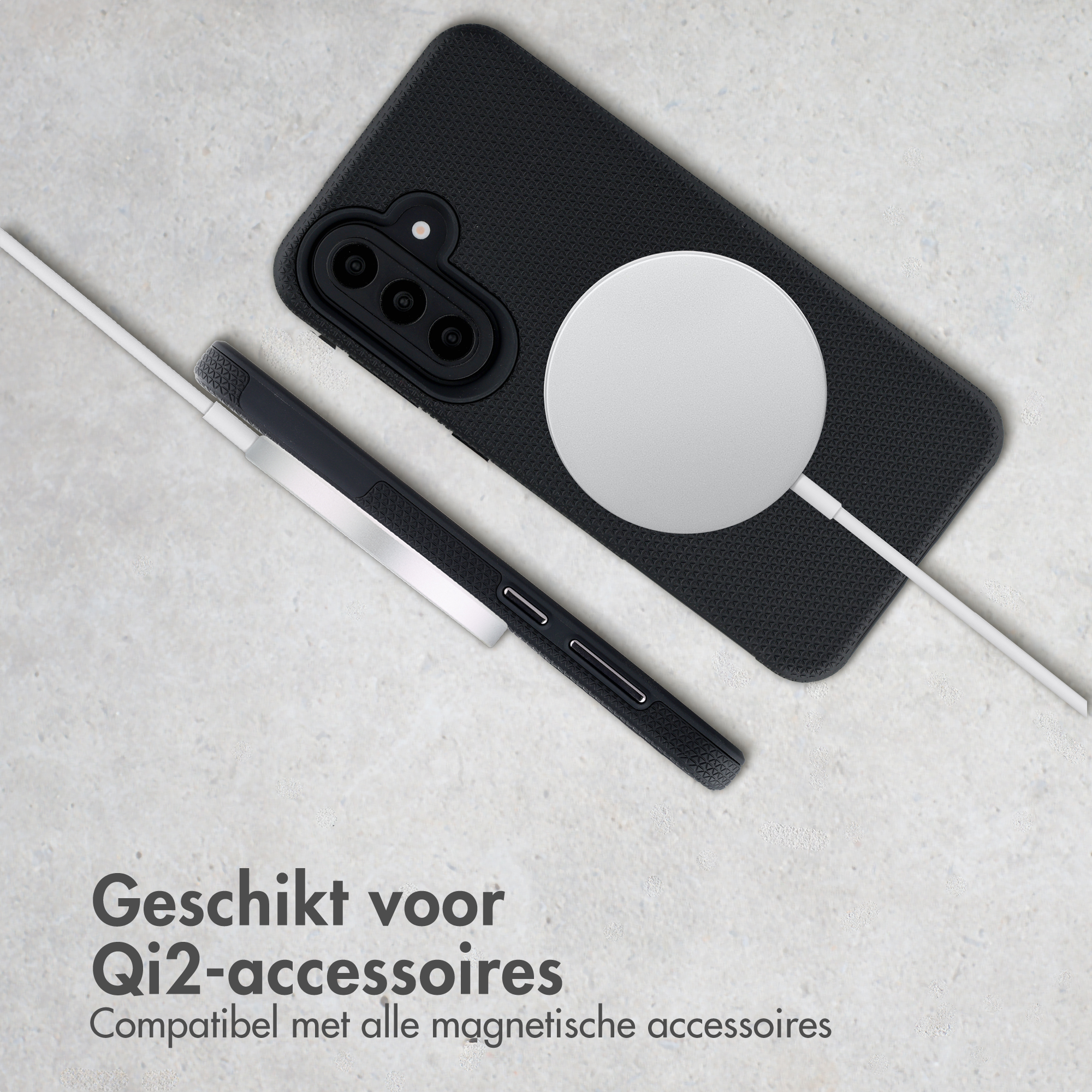 Zwarte telefoon met magnetische oplaadplaat en wit kabel op grijze ondergrond.
