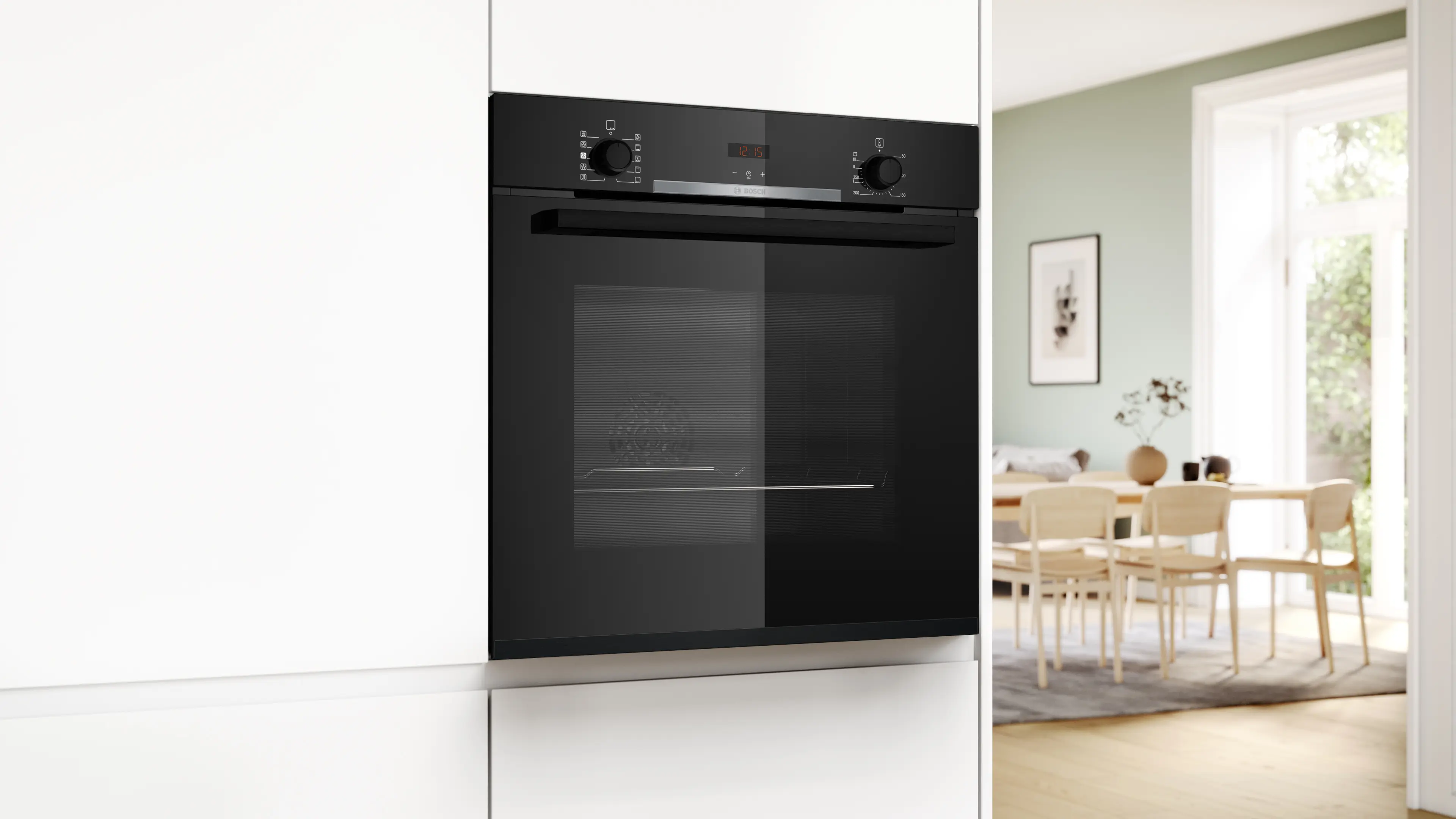 Un moderno forno da incasso nero accanto ad armadi bianchi, sala da pranzo sullo sfondo.