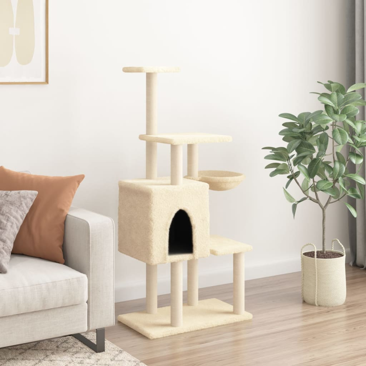 Ein beiger Kratzbaum mit Hängematte und Haus neben einem Sofa und einer Pflanze.