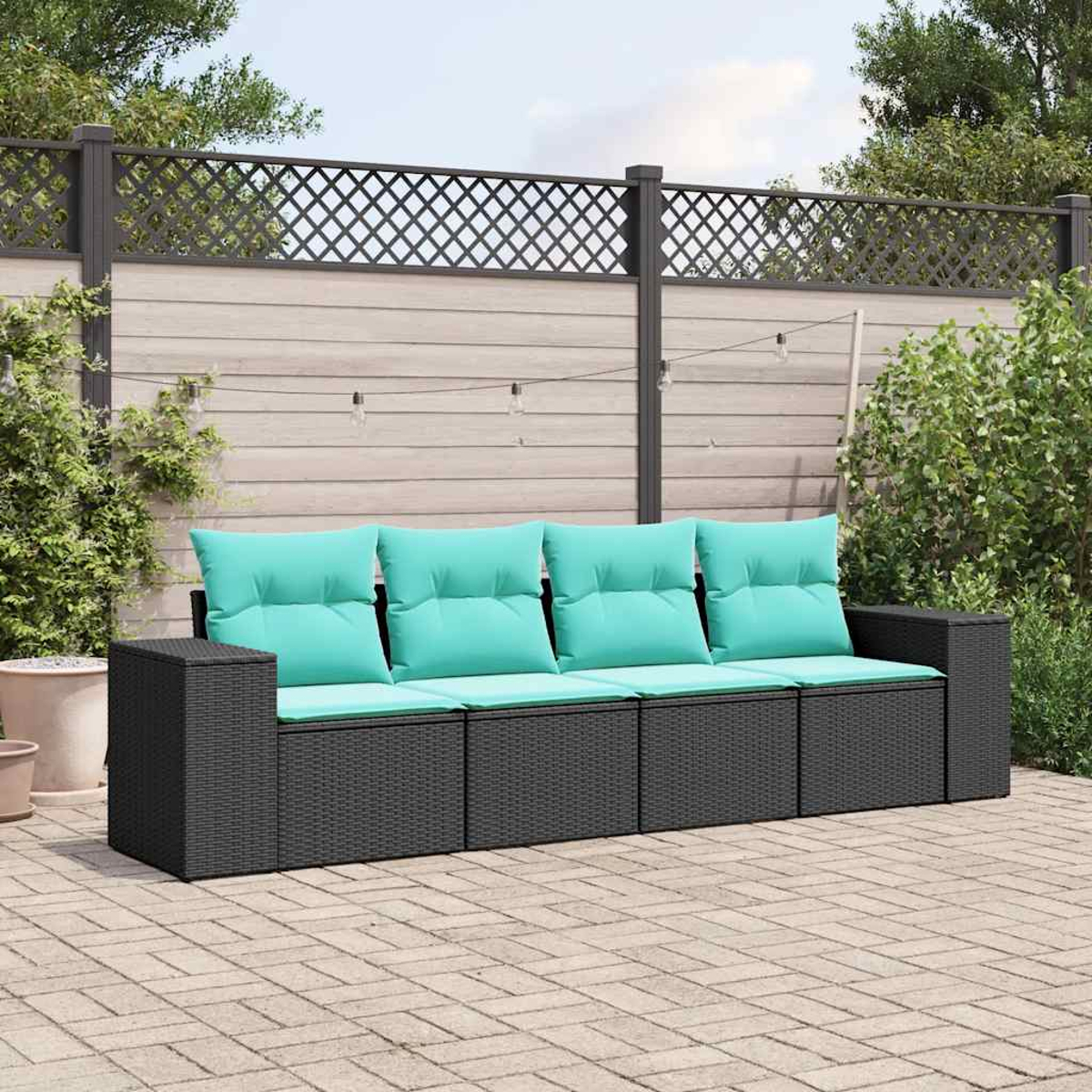 Dunkelgraues Lounge-Sofa mit türkisfarbenen Kissen auf einer Steinterrasse.
