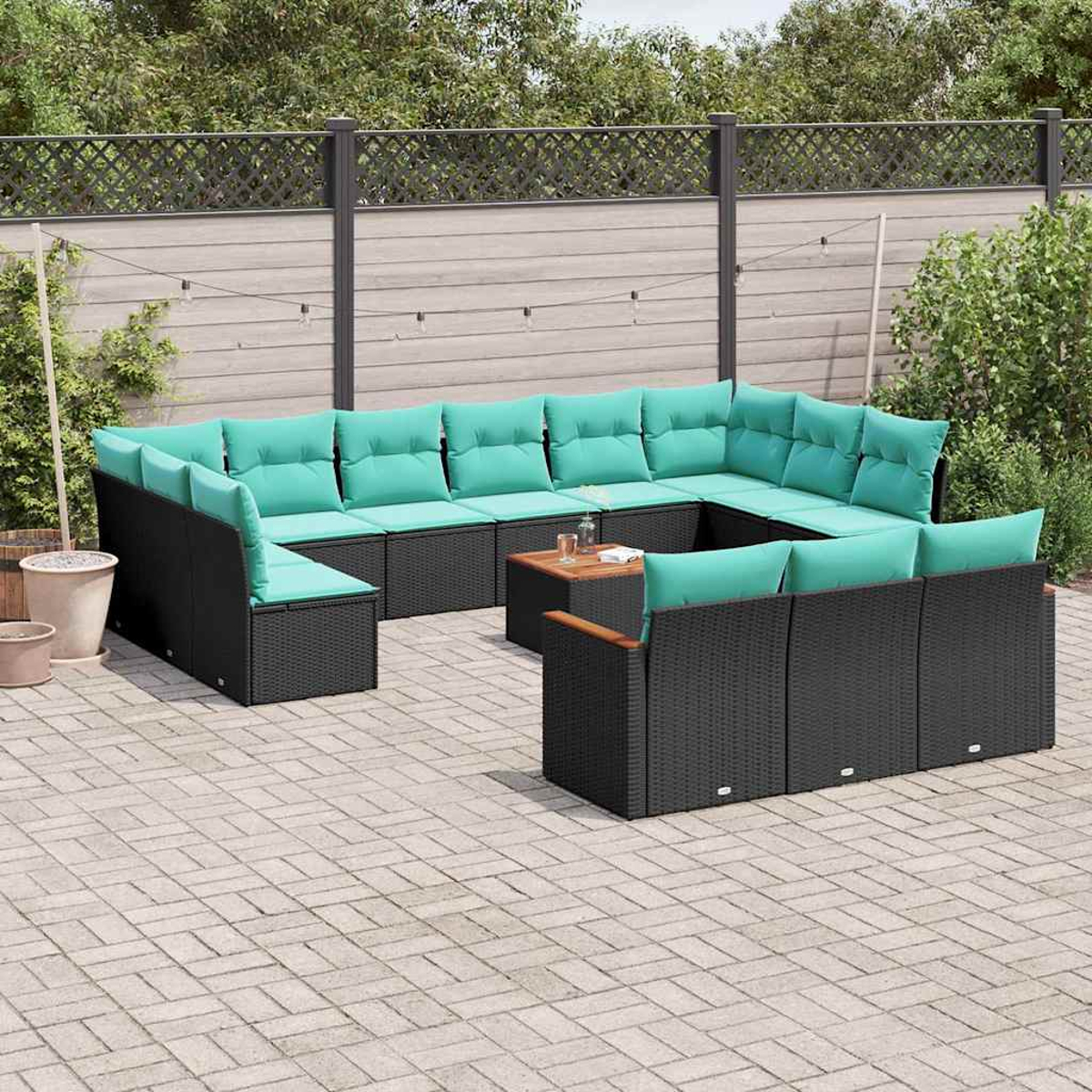 Ein modulares Outdoor-Sofa mit schwarzen Rattanstühlen und türkisfarbenen Kissen.
