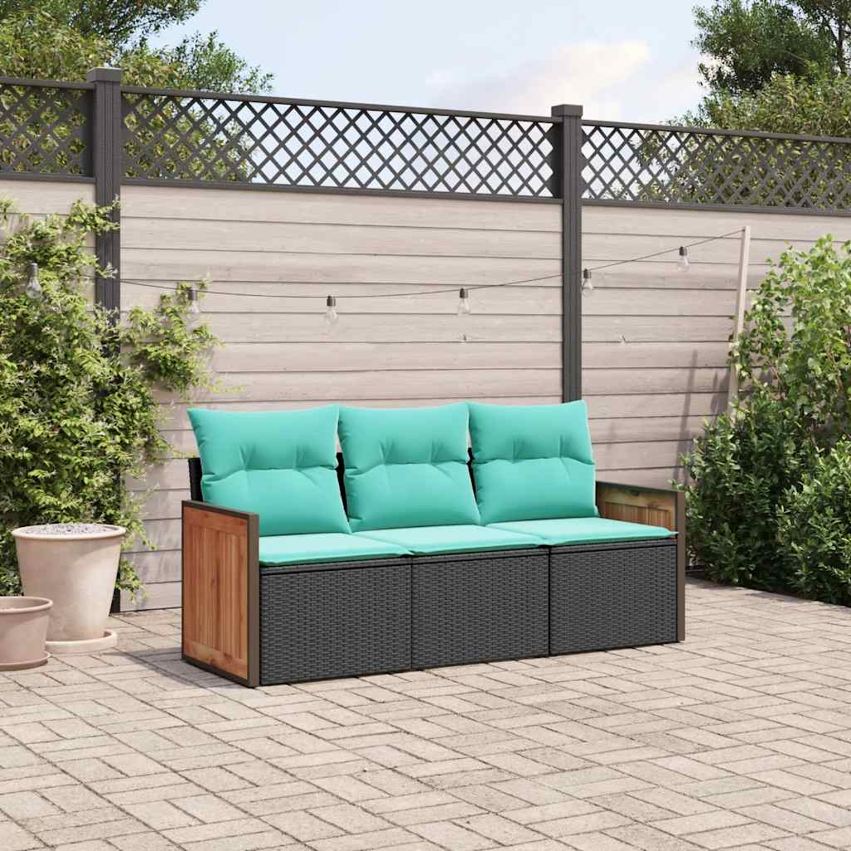 Ein Outdoor-Sofa mit türkisfarbenen Polstern steht auf einer gepflasterten Terrasse.
