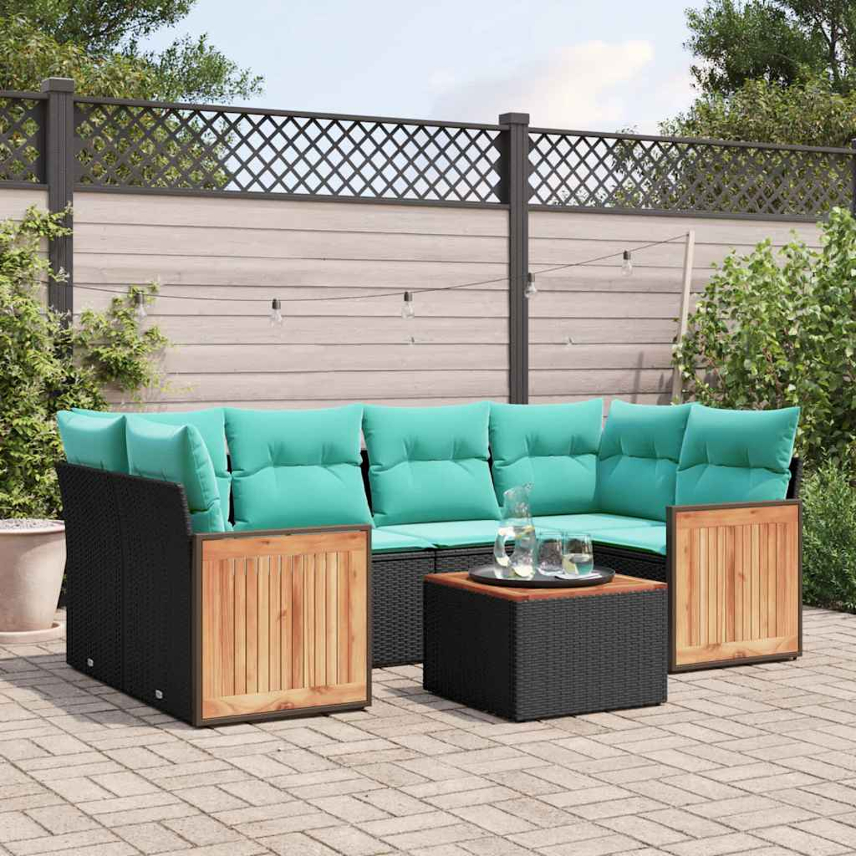 Un sofá modular de ratán para exteriores con cojines turquesa y detalles de madera.