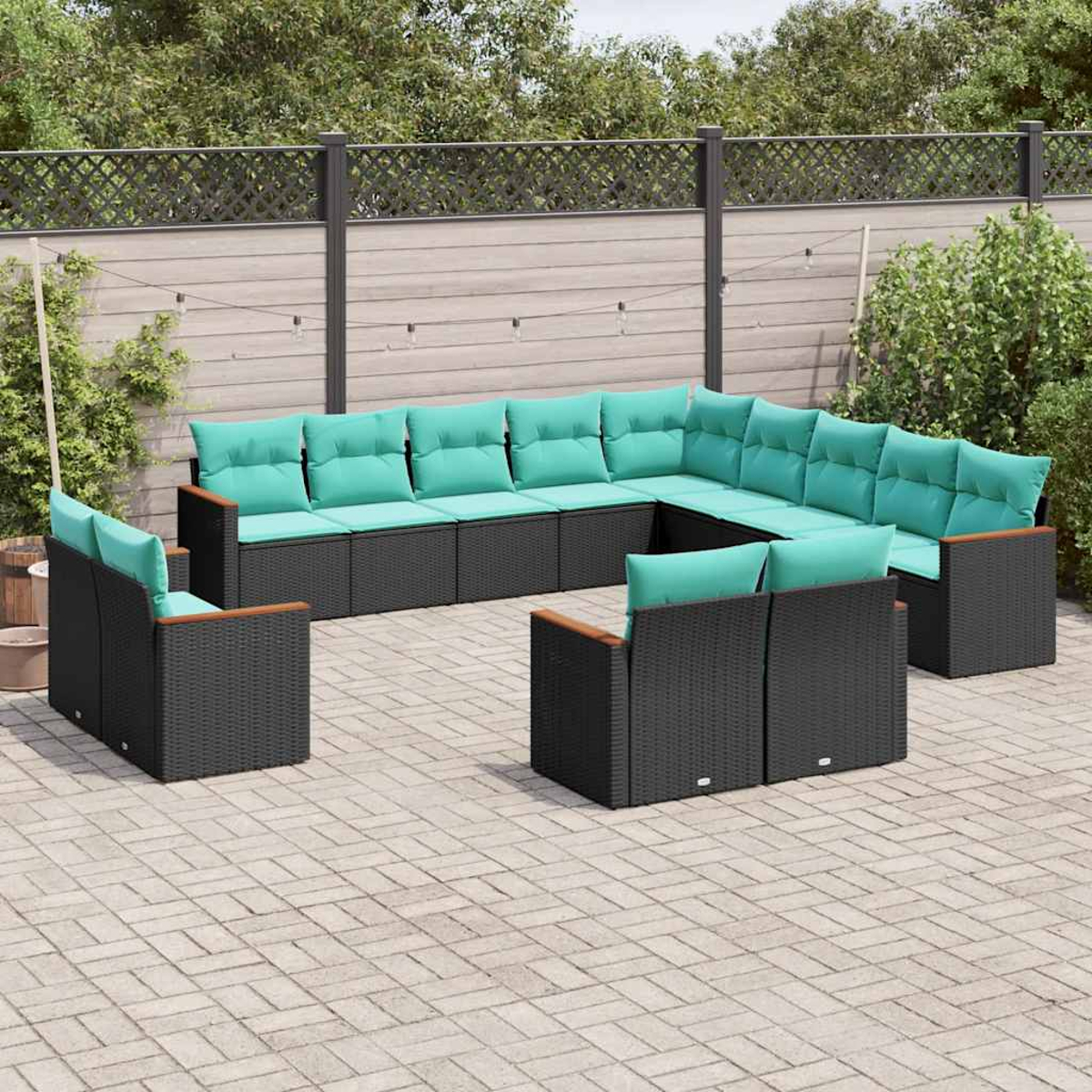 Ein modulares Outdoor-Lounge-Set aus schwarzem Rattan mit türkisfarbenen Kissen.