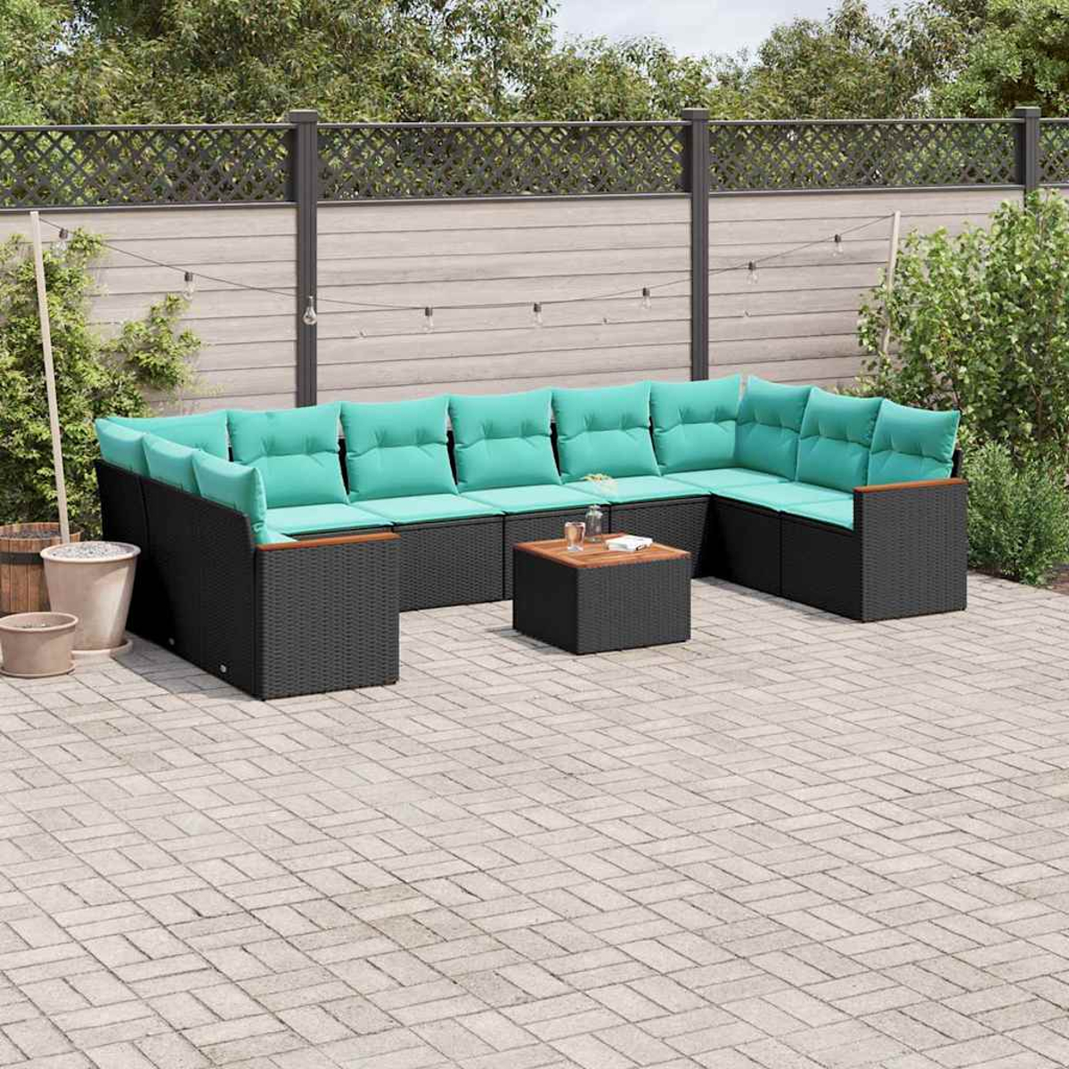 Ein modulares Rattan-Sofa mit türkisen Kissen und einem Holztisch auf einer gepflasterten Terrasse.
