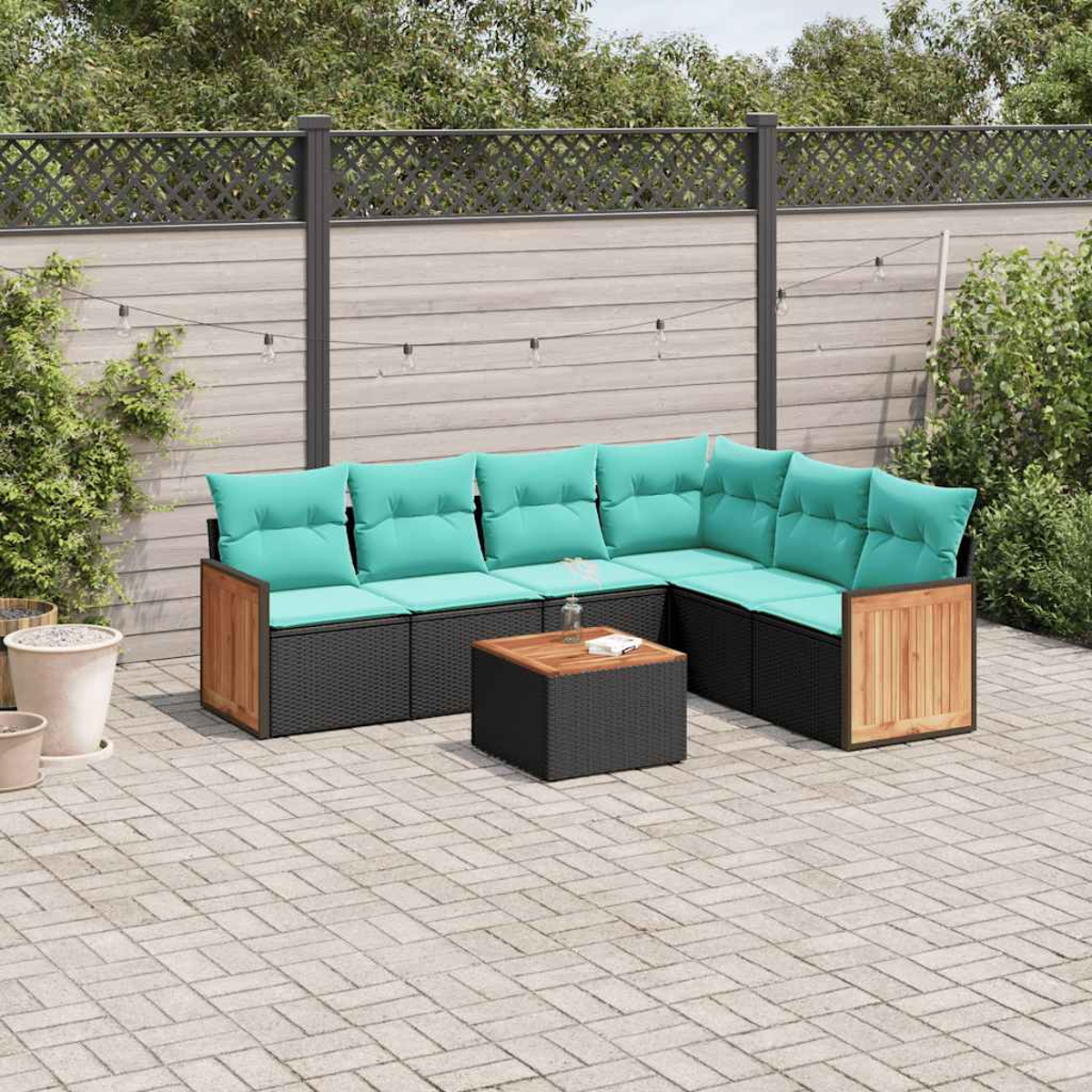 Eine Ecklounge mit türkisfarbenen Kissen und einem niedrigen Tisch auf einer Steinterrasse.