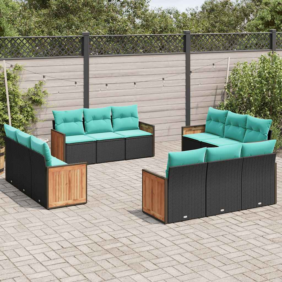 Moderne Gartenmöbel mit schwarzen Polstern und hellblauen Kissen auf gepflastertem Hof.