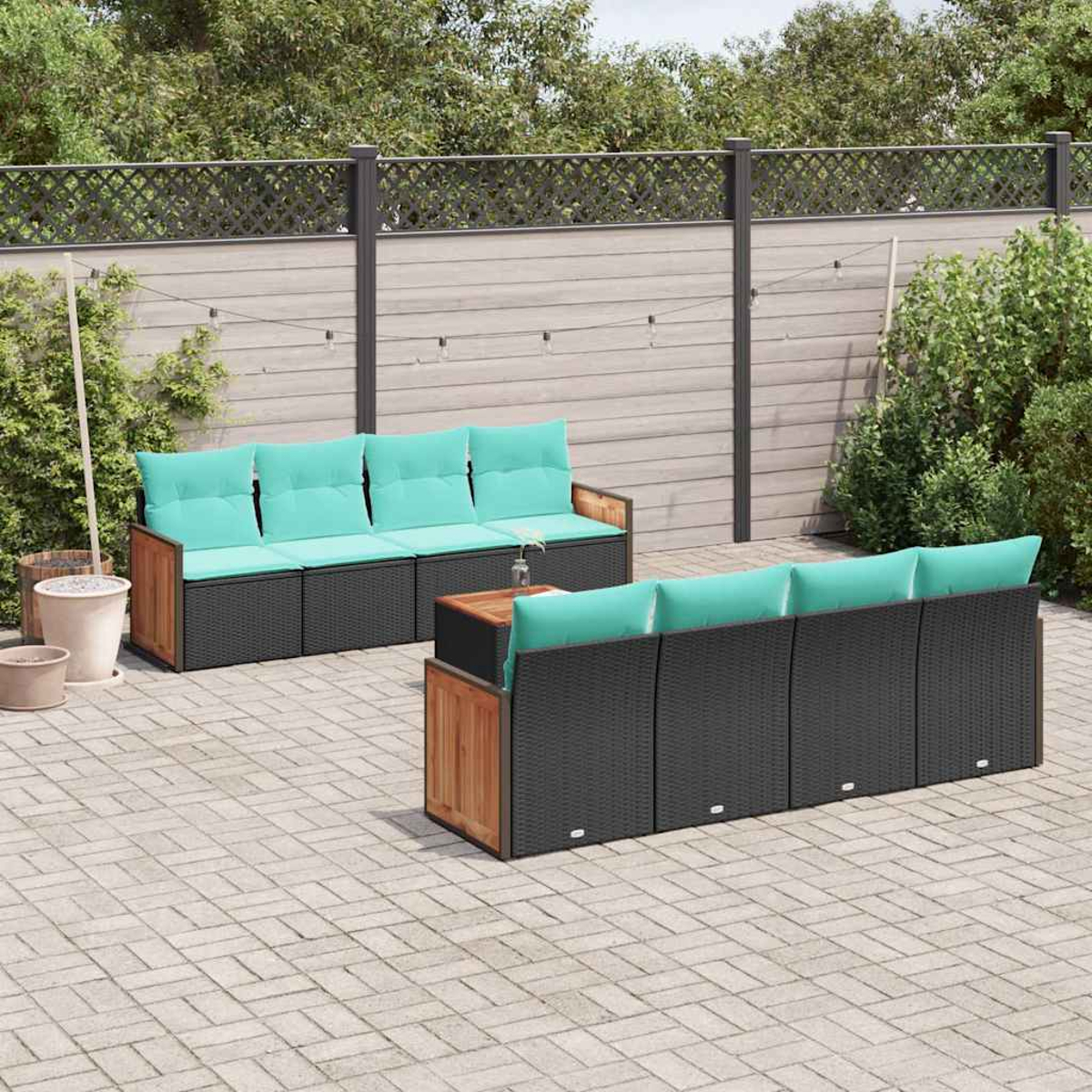 Gartenmöbel-Set mit schwarzen Rattansofas und hellgrünen Kissen.