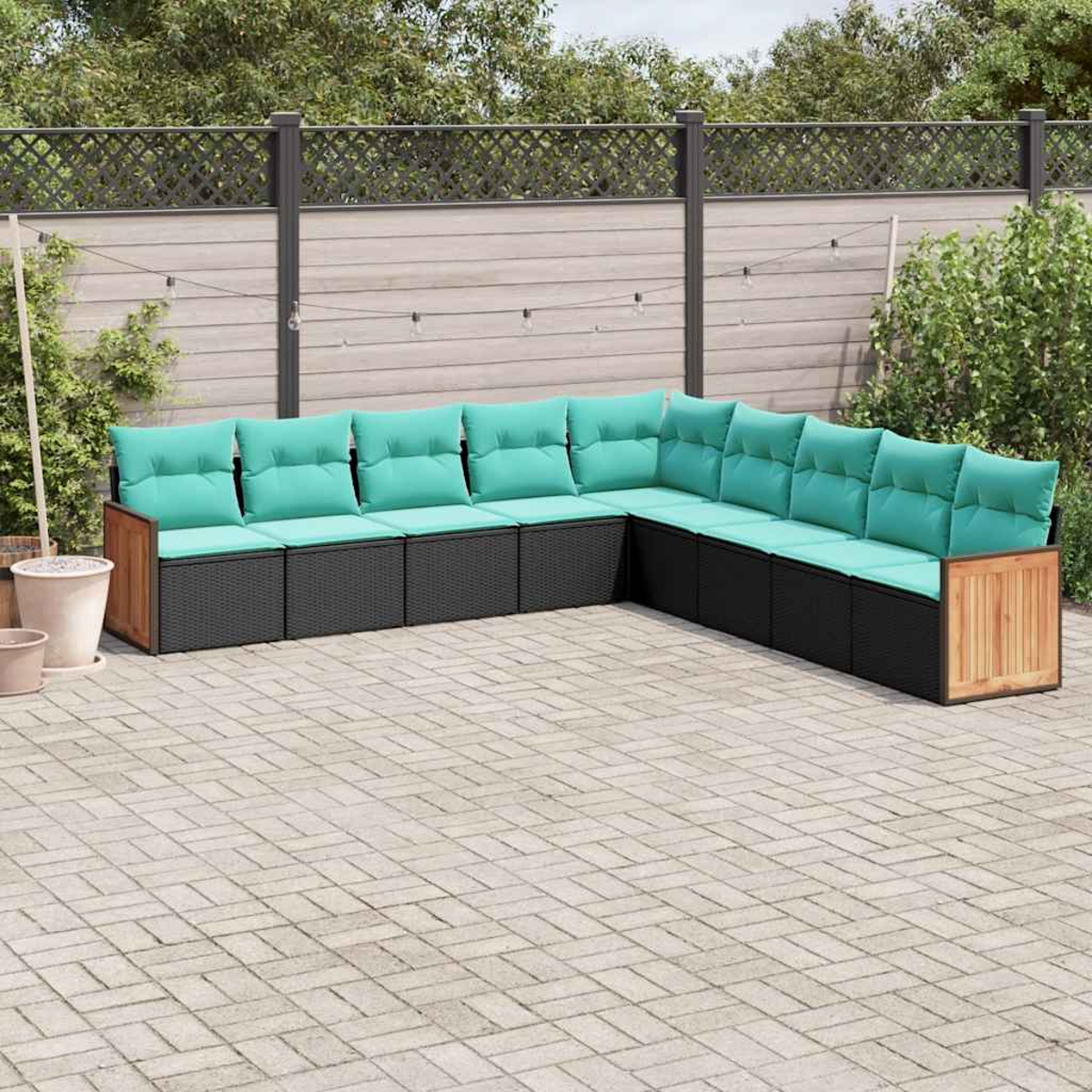 L-förmiges Outdoor-Sofa mit schwarzem Rattangeflecht und türkisfarbenen Kissen auf einer gepflasterten Terrasse.