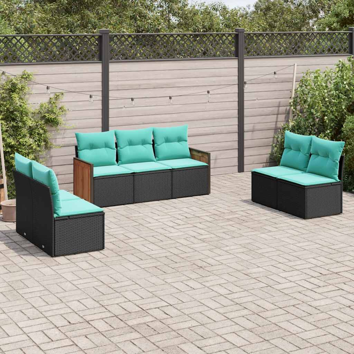 Drei schwarze Gartenmöbel-Module mit türkisen Polstern auf einer gepflasterten Terrasse.