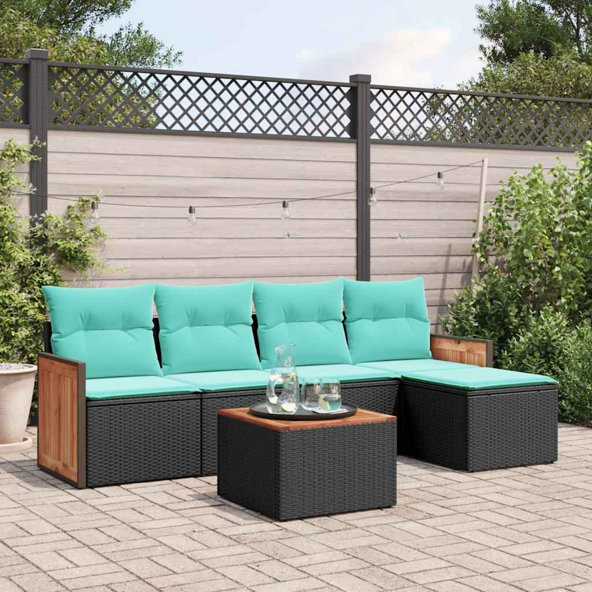 Outdoor-Sektionssofa mit türkisfarbenen Kissen und Couchtisch auf gepflasterter Terrasse.
