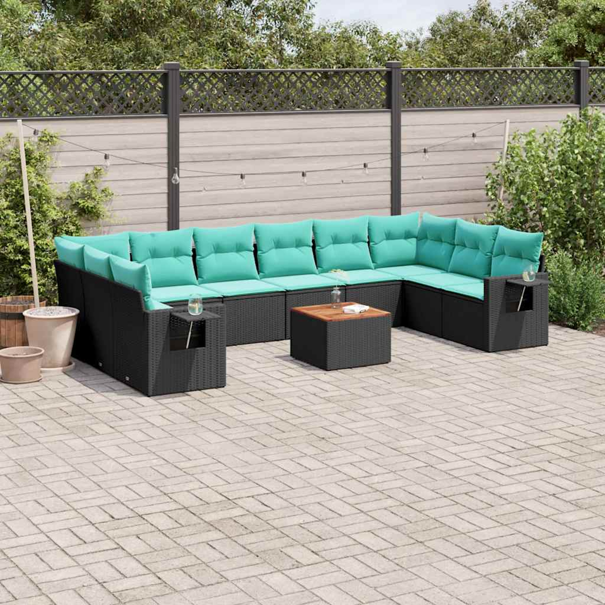 U-förmige schwarze Lounge-Garnitur mit türkisfarbenen Kissen auf einer gepflasterten Terrasse.