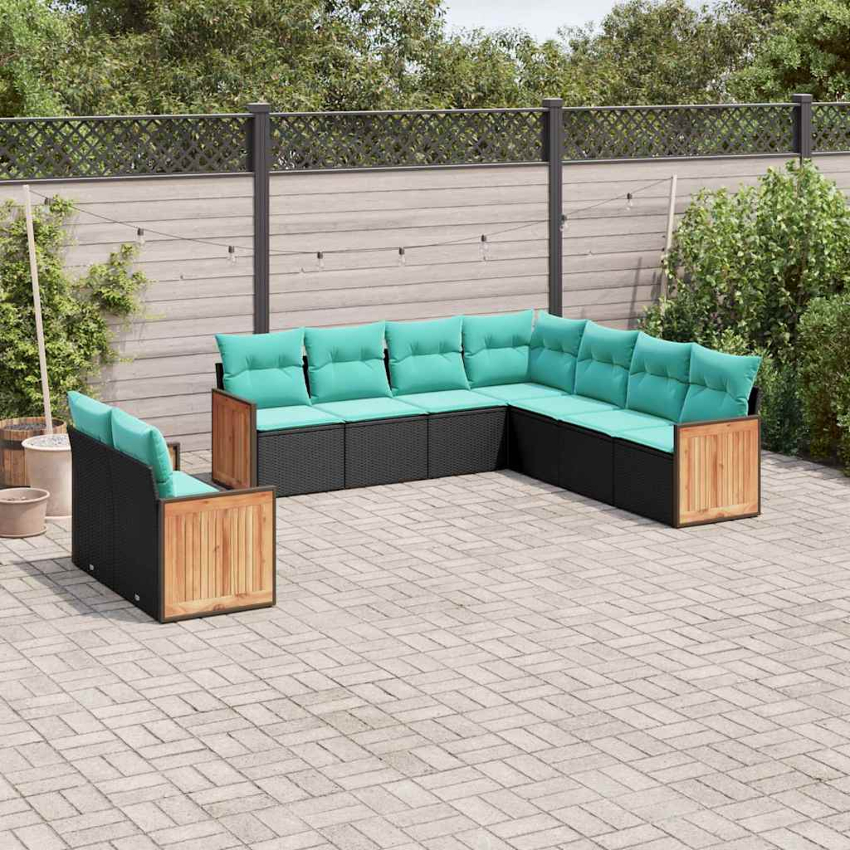Ein L-förmiges Outdoor-Sofa mit hellgrünen Kissen auf einem gepflasterten Hof.