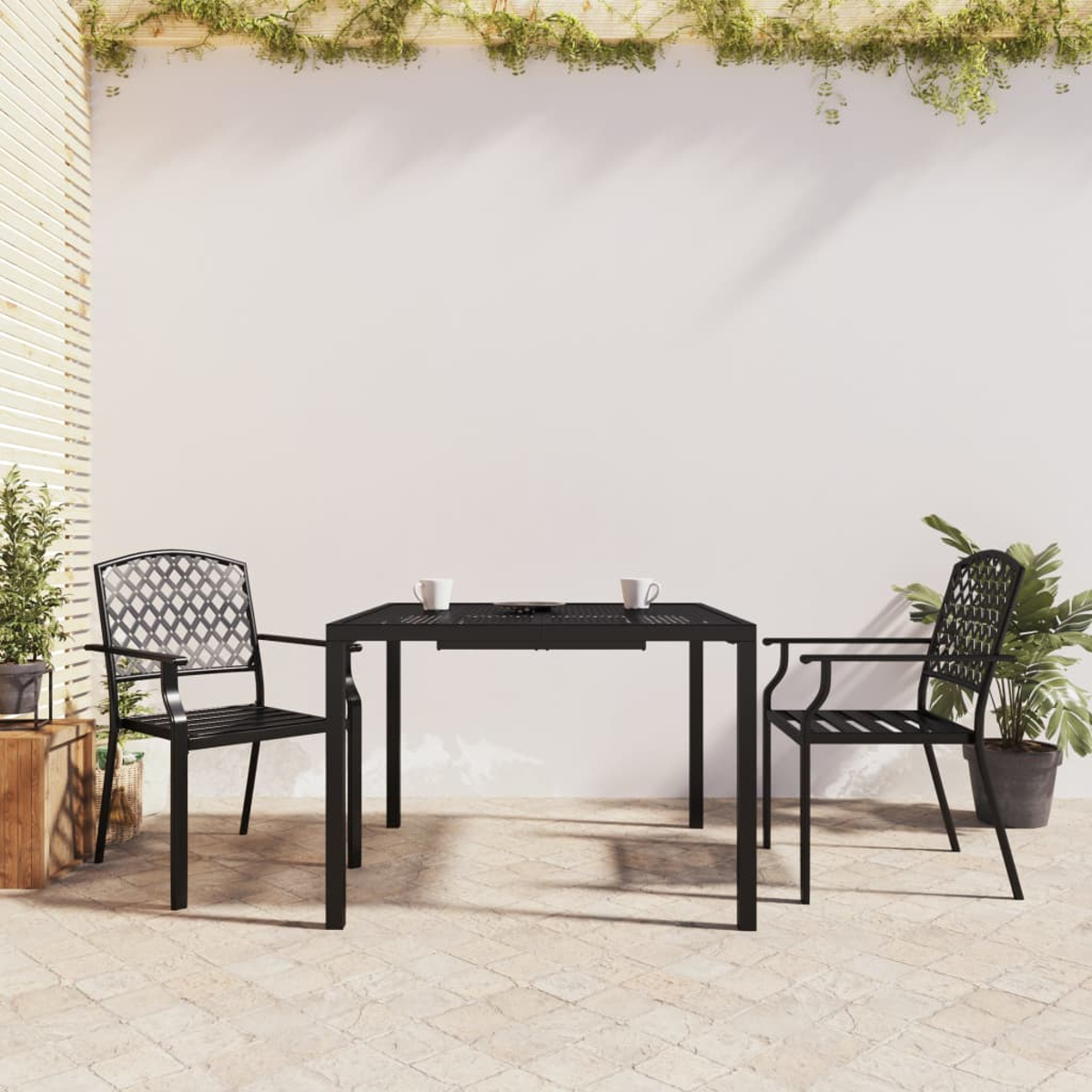 Schwarzer Gartentisch mit zwei Stühlen, Tassen und Pflanzen.