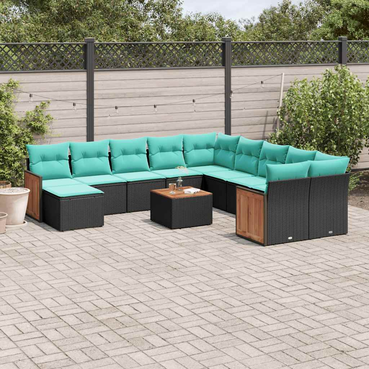 Ein L-förmiges Outdoor-Sofa aus schwarzem Rattan mit türkisfarbenen Kissen und Holzakzenten.