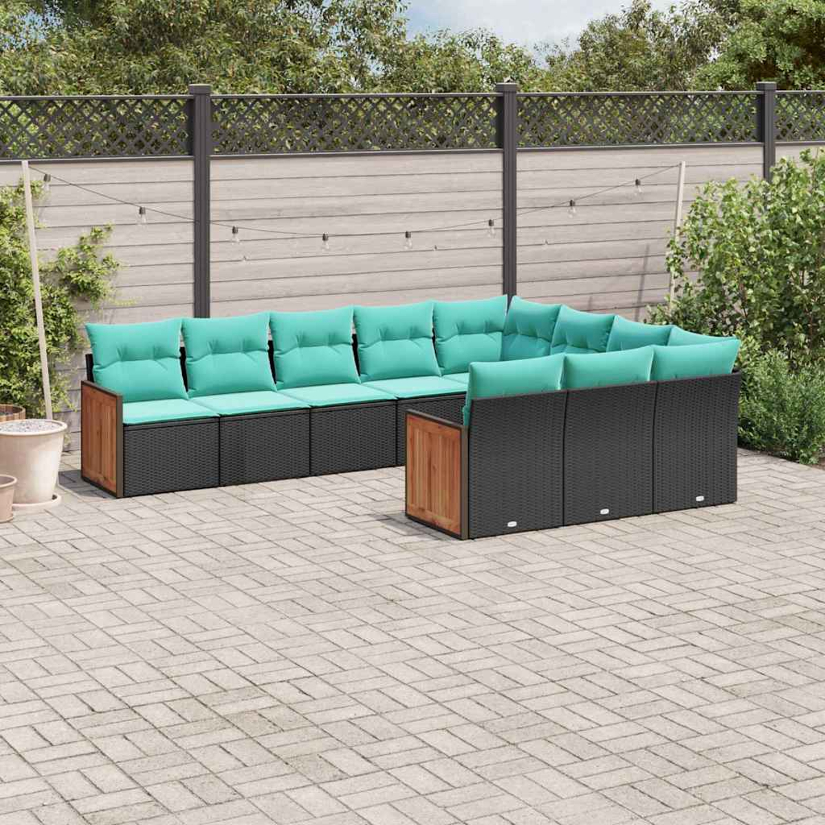 Ecklounge-Set aus schwarzem Rattan mit türkisfarbenen Kissen auf einer gepflasterten Terrasse.