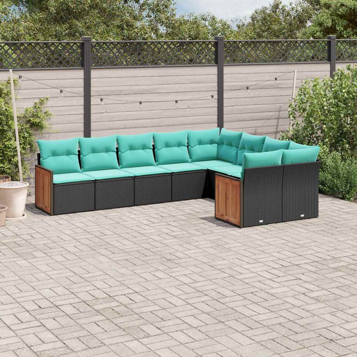 Ein modulares Outdoor-Sofa mit tealfarbenen Kissen steht auf einer gepflasterten Terrasse.