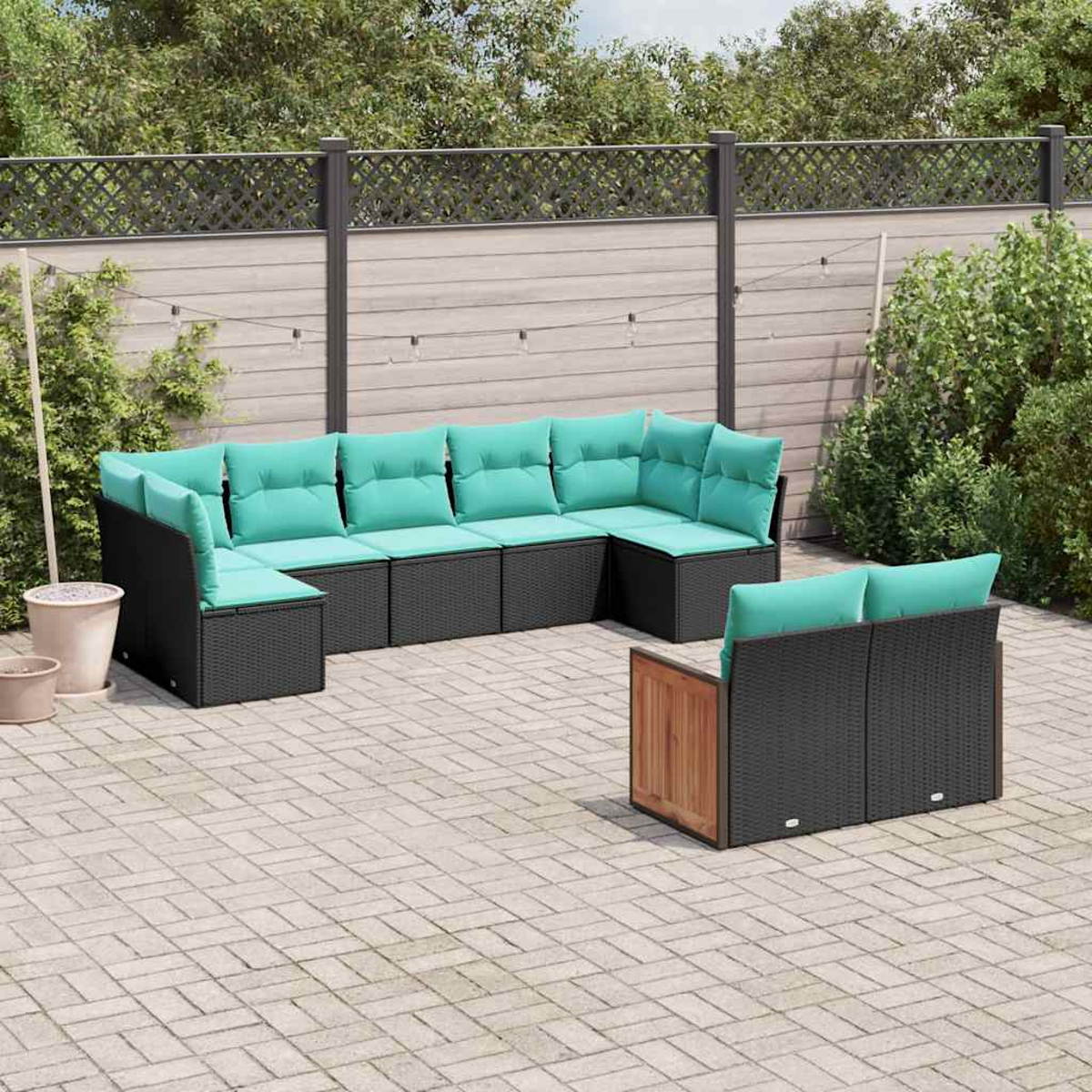Ein moderner, schwarzer Rattansofa-Set mit türkisfarbenen Kissen auf einer gepflasterten Terrasse.