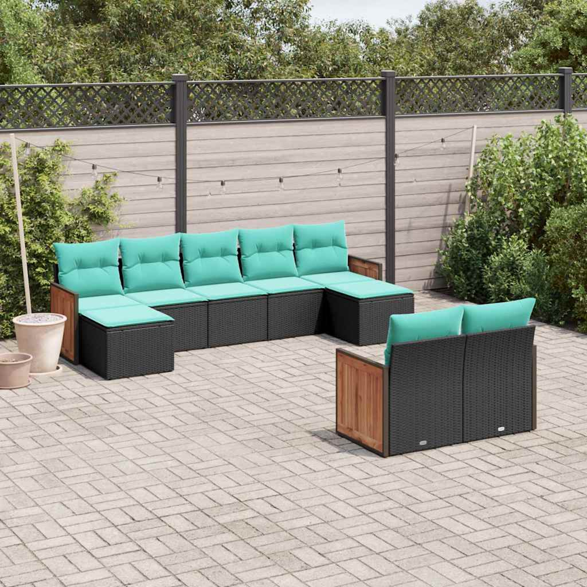 Moderne Outdoor-Lounge-Möbel mit schwarzen Rattan-Elementen und hellgrünen Kissen.