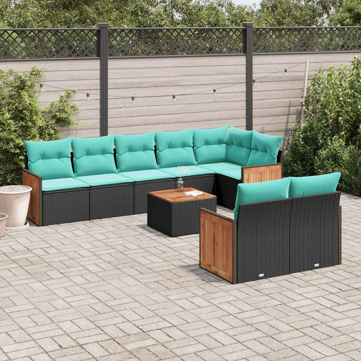 Gartenlounge-Set mit schwarzen Rattan-Modulen und türkisfarbenen Kissen.