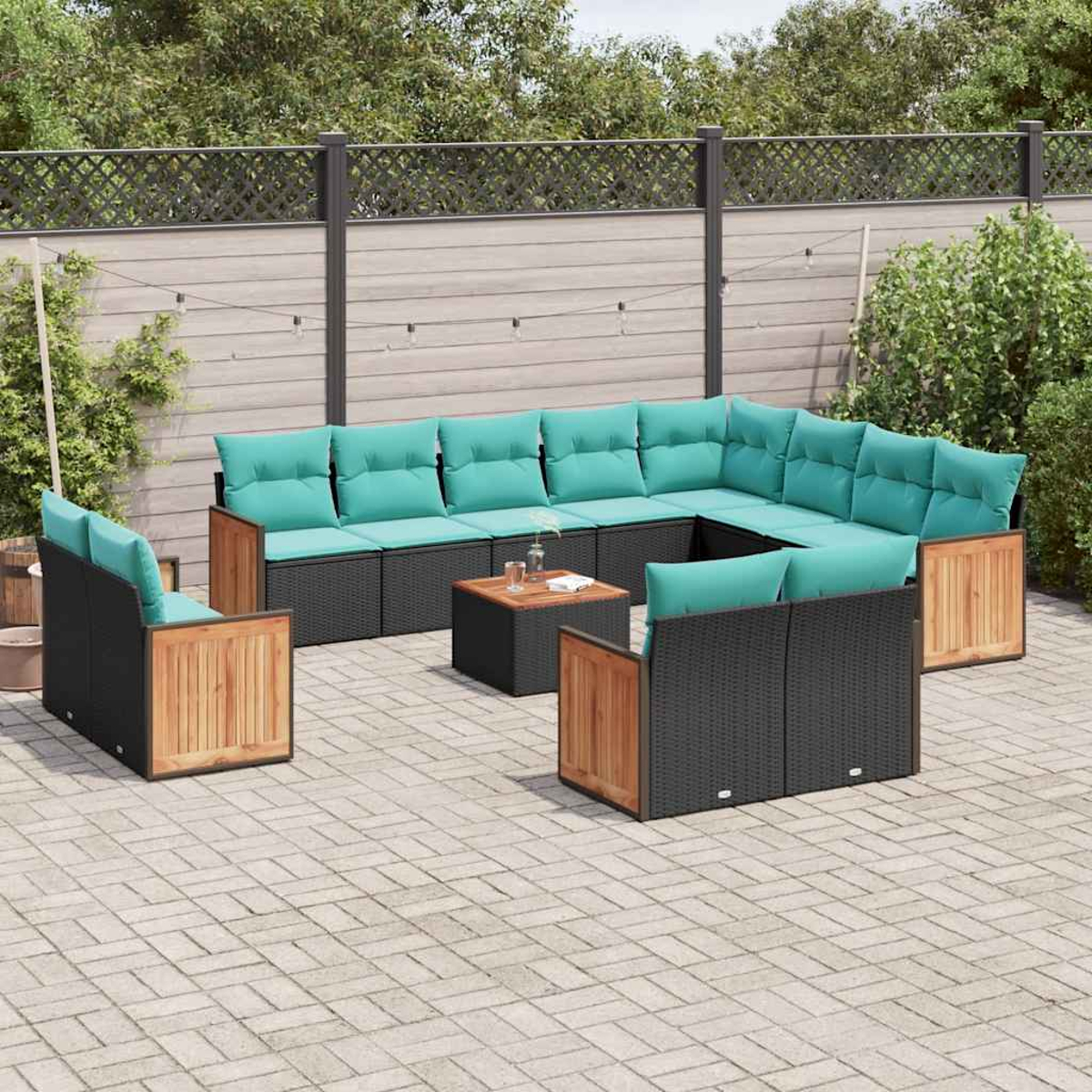 Ein modulares Outdoor-Sofa mit hellblauen Kissen und Holzakzenten auf einer gepflasterten Terrasse.