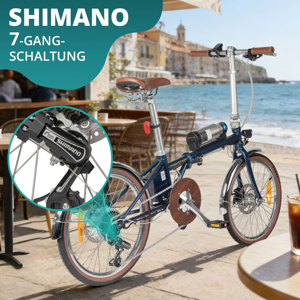 Bicicletta pieghevole blu con cambio Shimano a 7 velocità, sul mare.