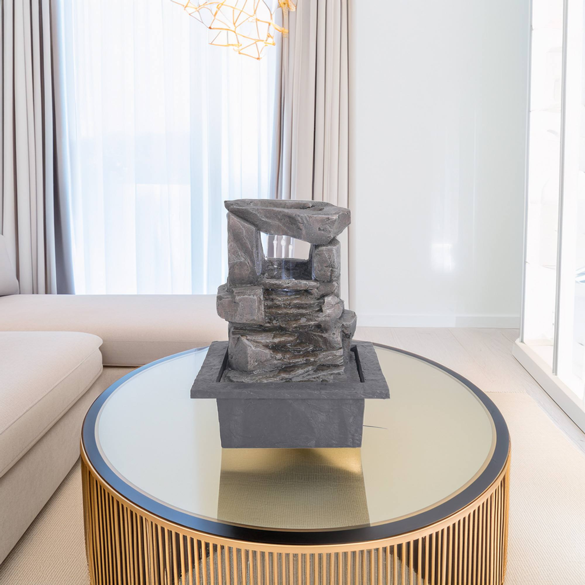 Una fuente de piedra sobre una mesa redonda con tapa de espejo en una habitación luminosa.