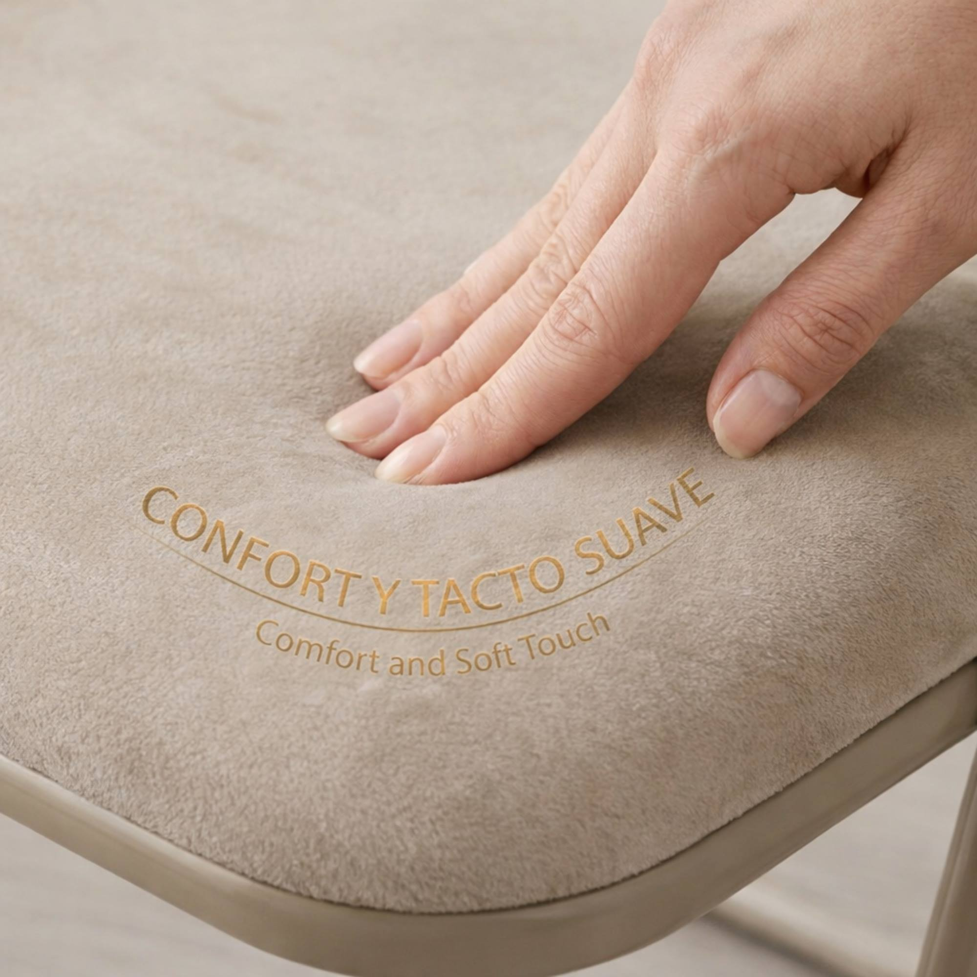 Una mano presiona suavemente un cojín beige con texto dorado.
