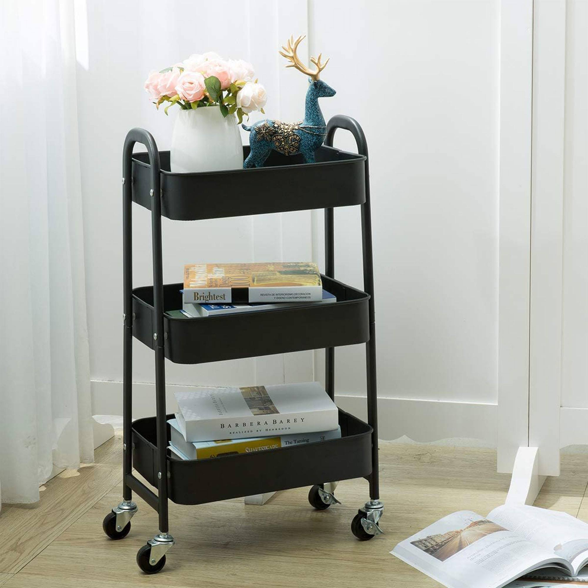 Carro negro de 3 niveles con flores, ciervo decorativo y libros.