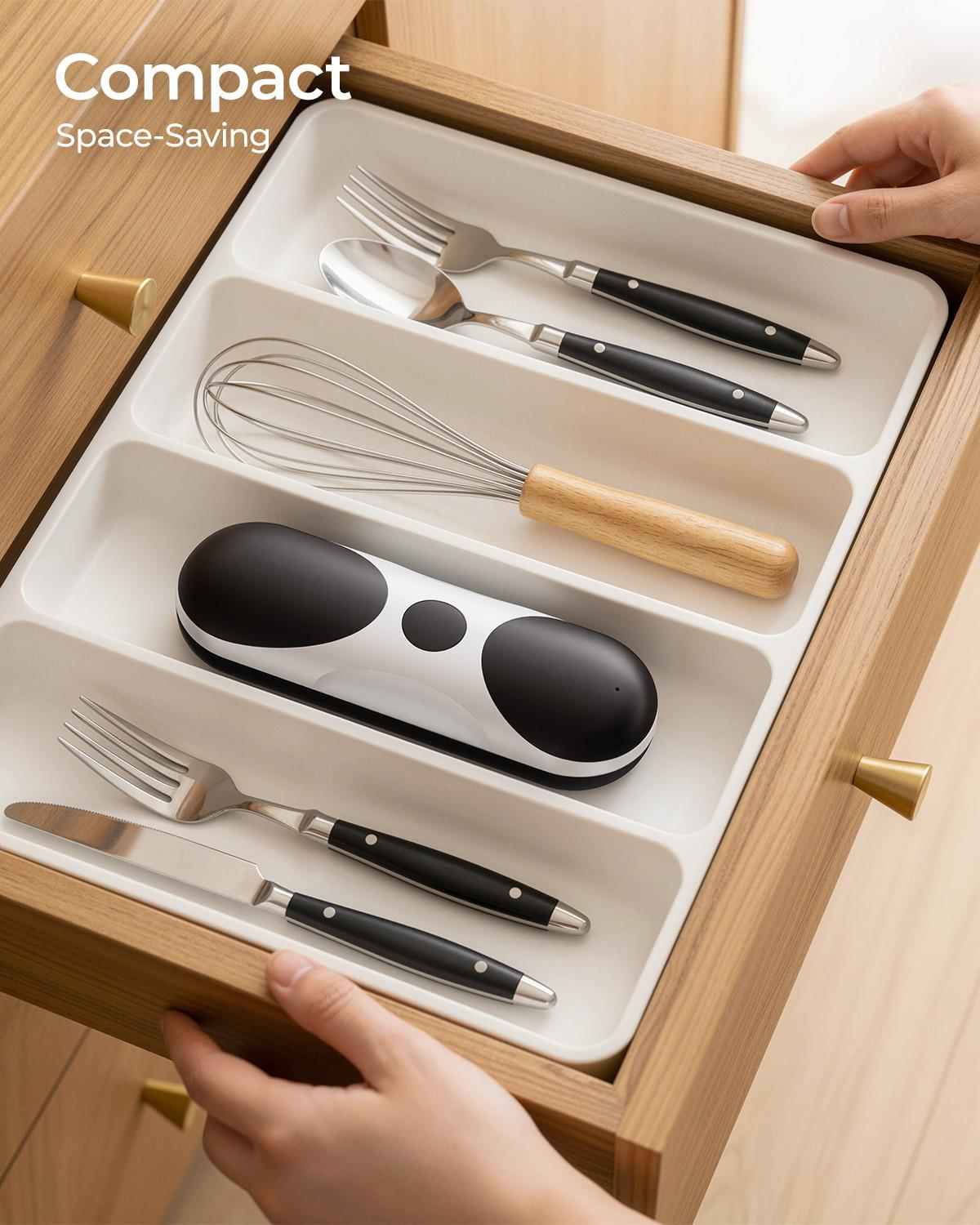 Besteckschublade mit Utensilien: Gabeln, Löffel, Schneebesen und ein schwarzes Gerät.