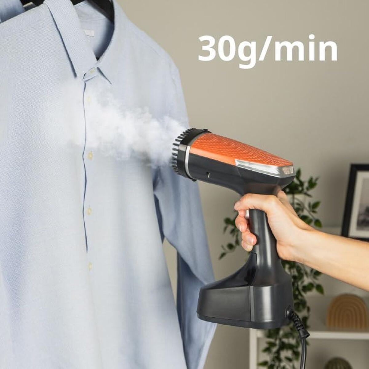 Un vaporizzatore portatile stira una camicia blu con 30g/min di vapore.