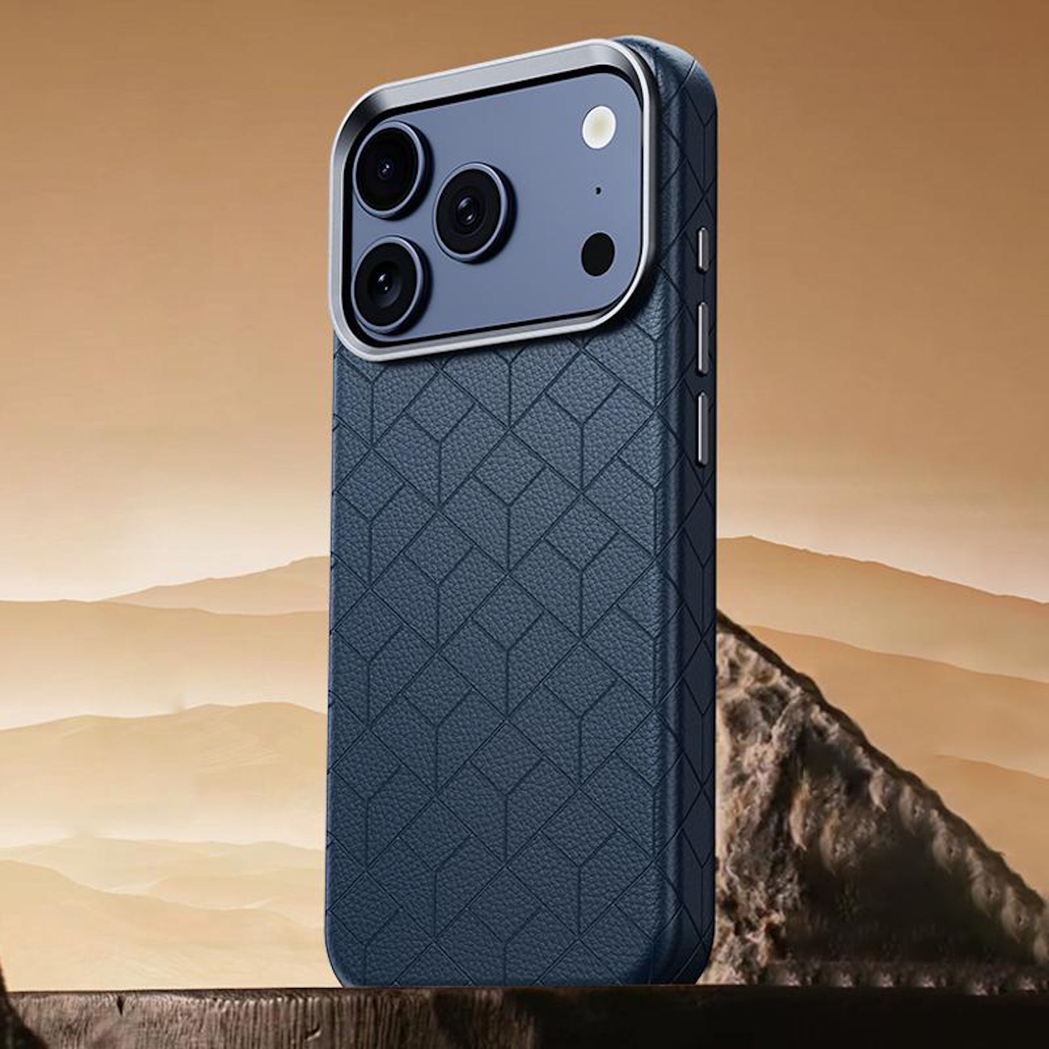 Funda de teléfono azul oscuro con patrón geométrico, primer plano, fondo desértico.